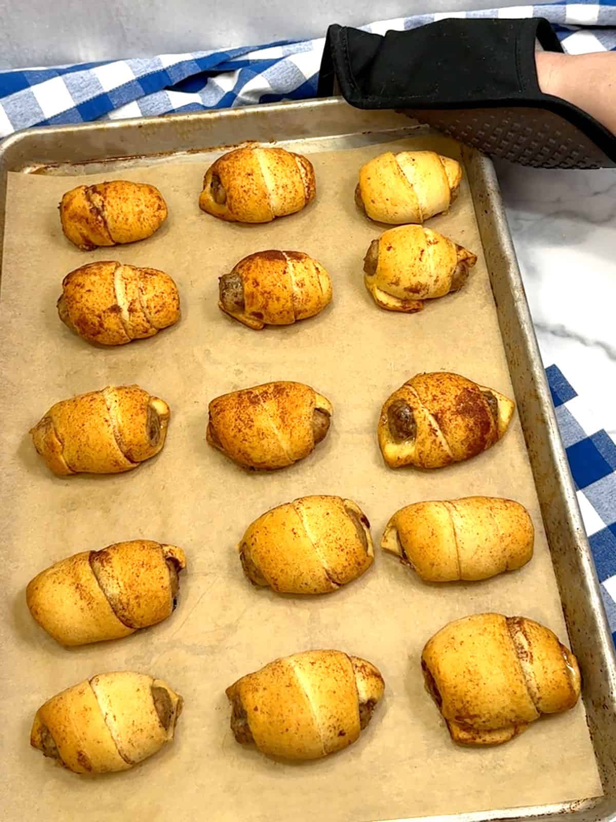 removing cinnamon rolls pigs in a blanket from the oven