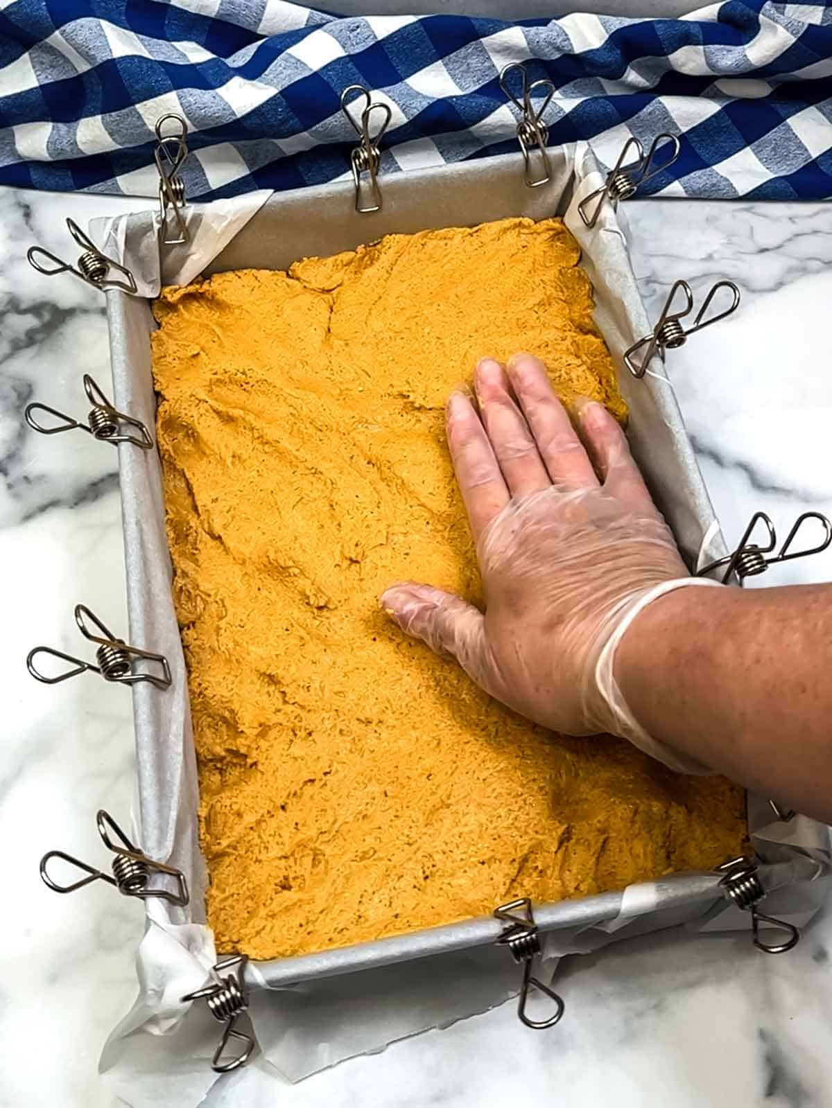 pressing peanut butter mixture into prepared pan
