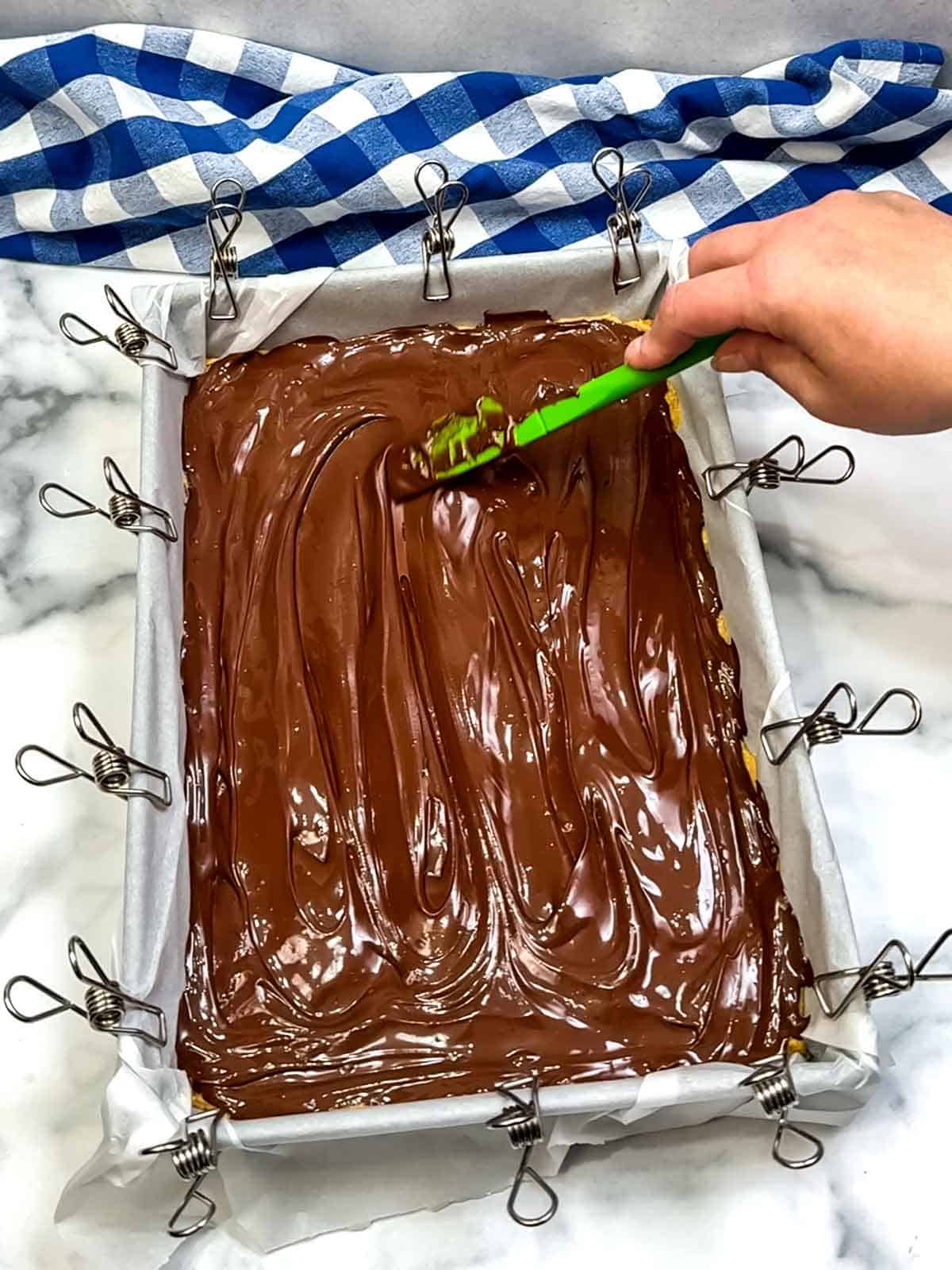 spreading chocolate over peanut butter mixture
