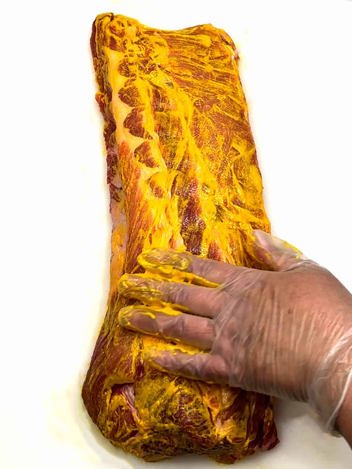 spreading mustard on ribs