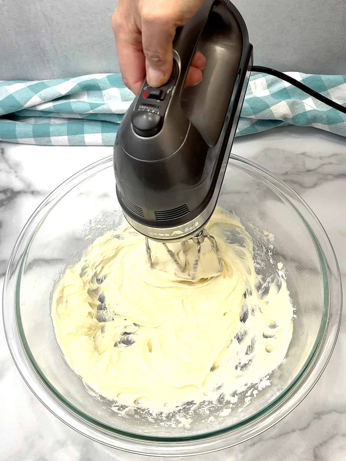 beating powdered sugar and cream cheese for topping
