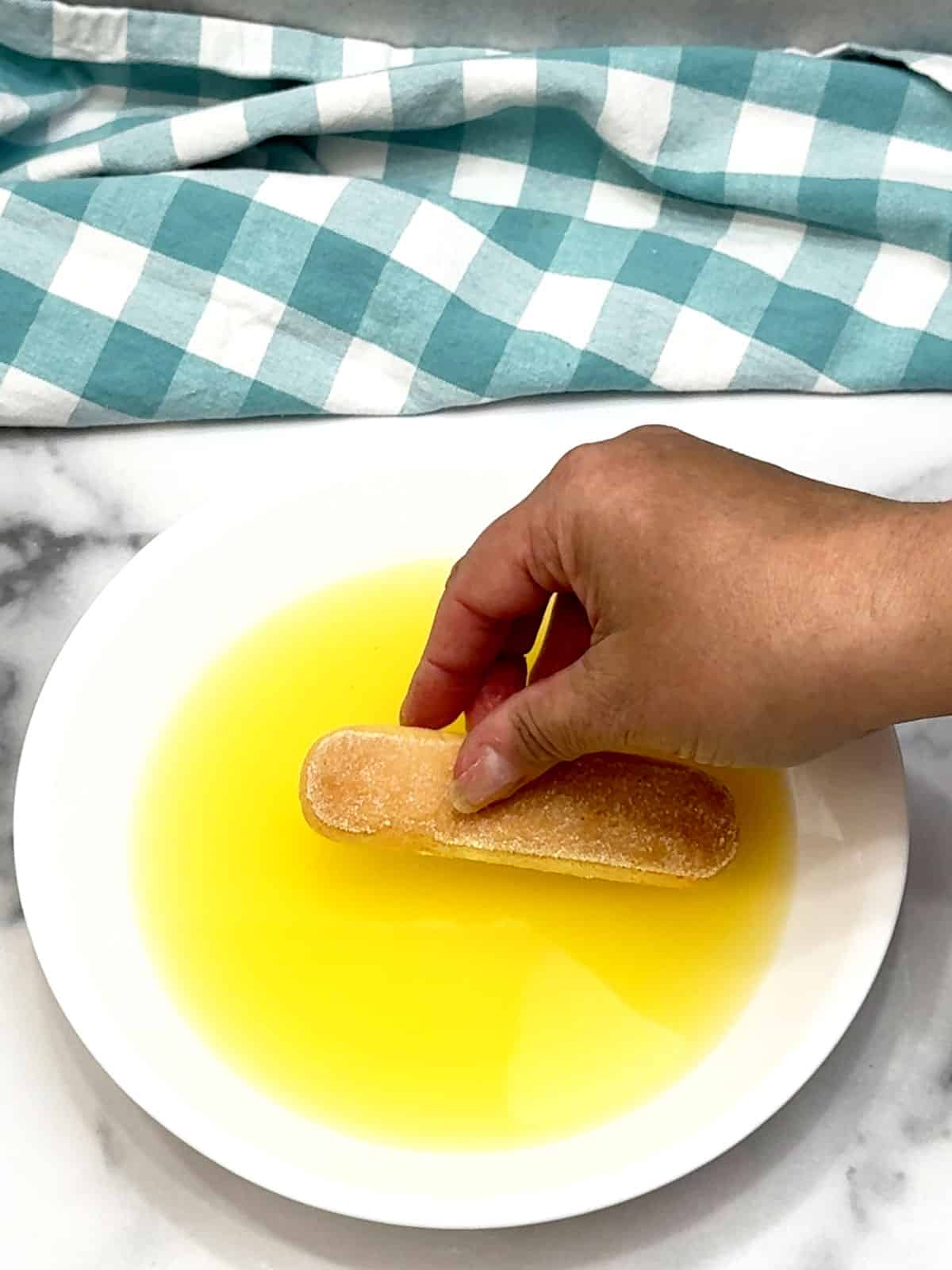 dipping ladyfingers in lemon syrup
