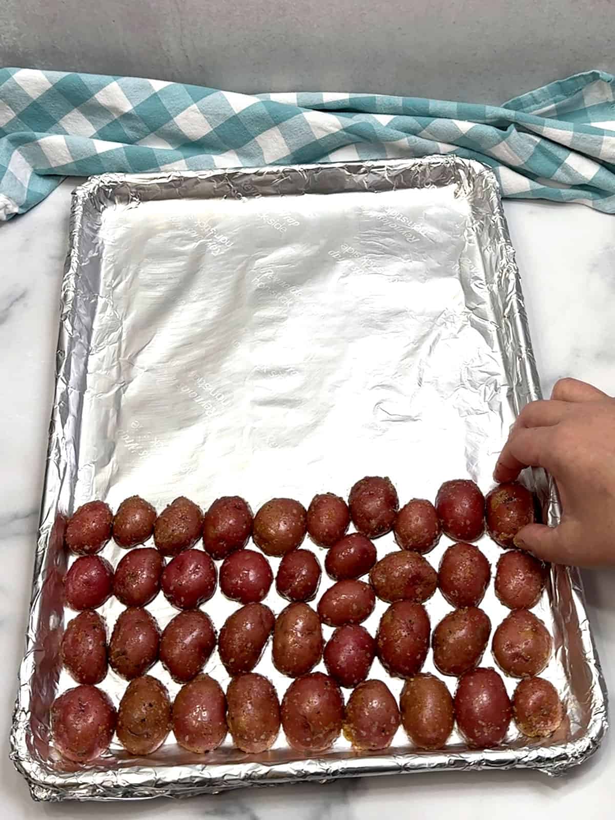 placing potatoes on sheet pan