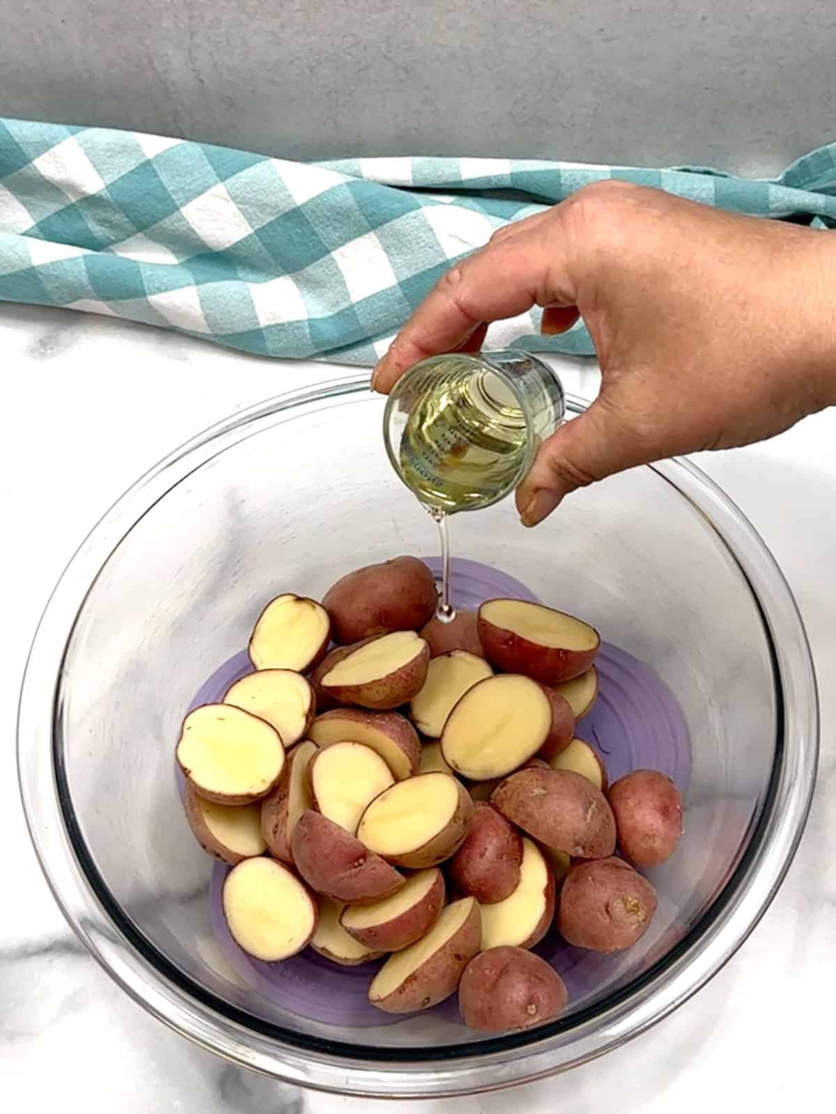 adding oil to potatoes
