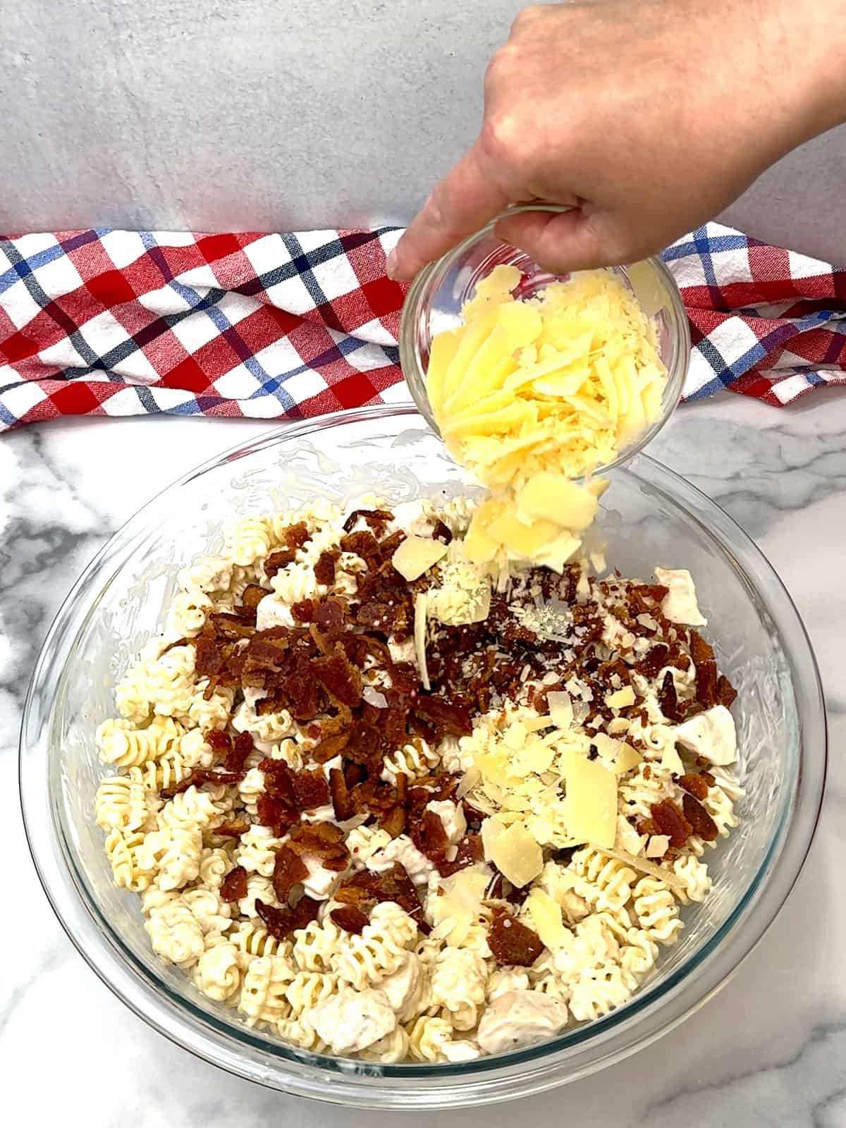 adding cooked & crumbled bacon and shaved parmesan cheese to pasta and chicken 