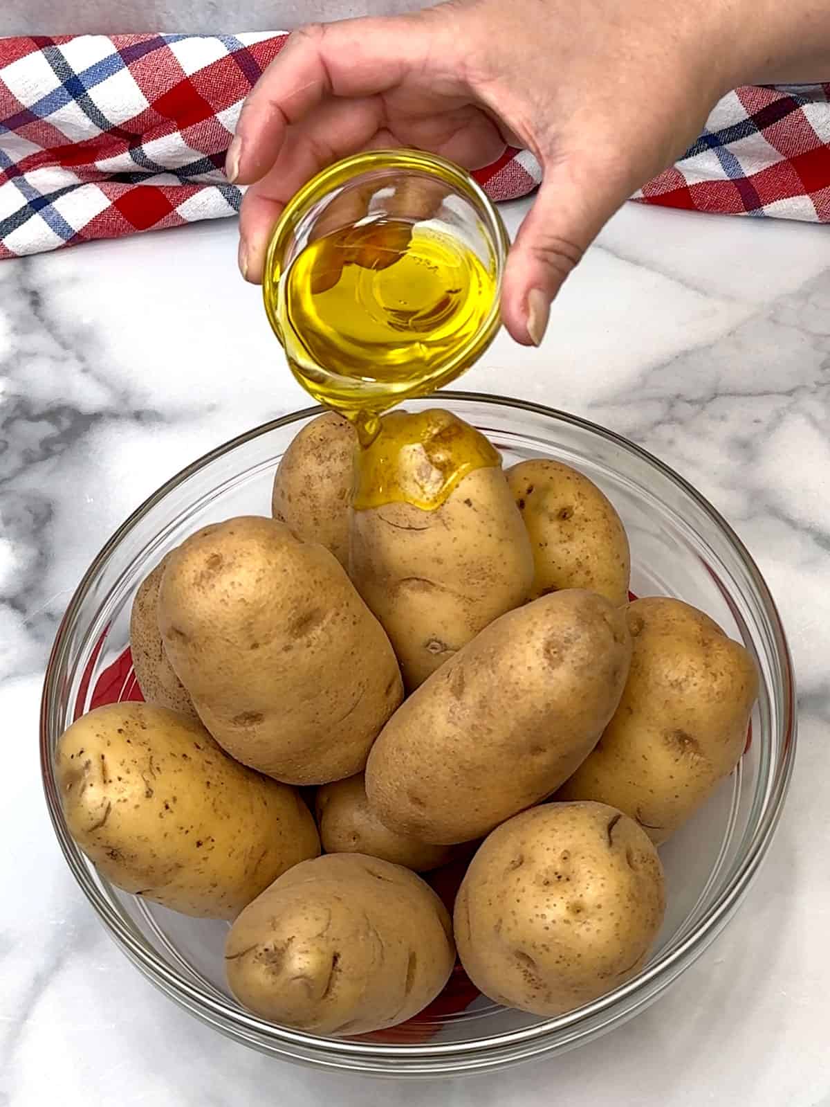 pouring oil over potatoes