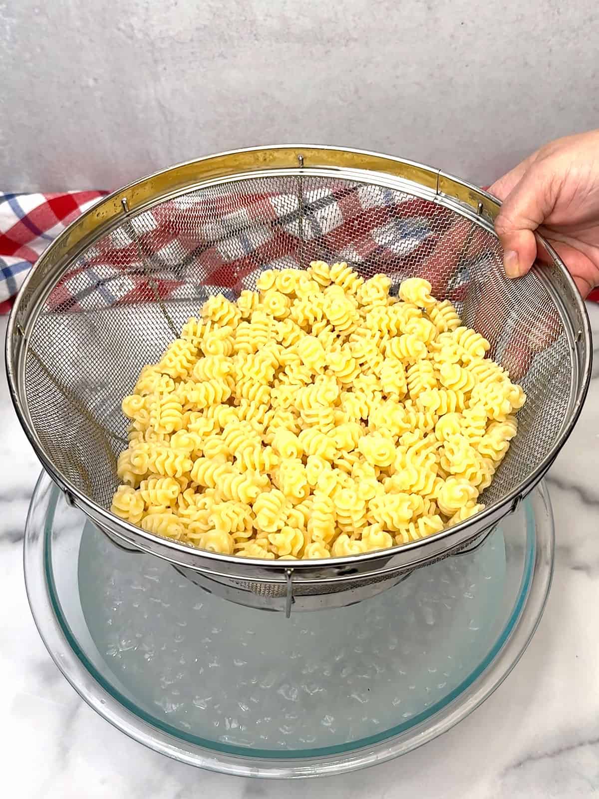 cooling cooked pasta in water bath