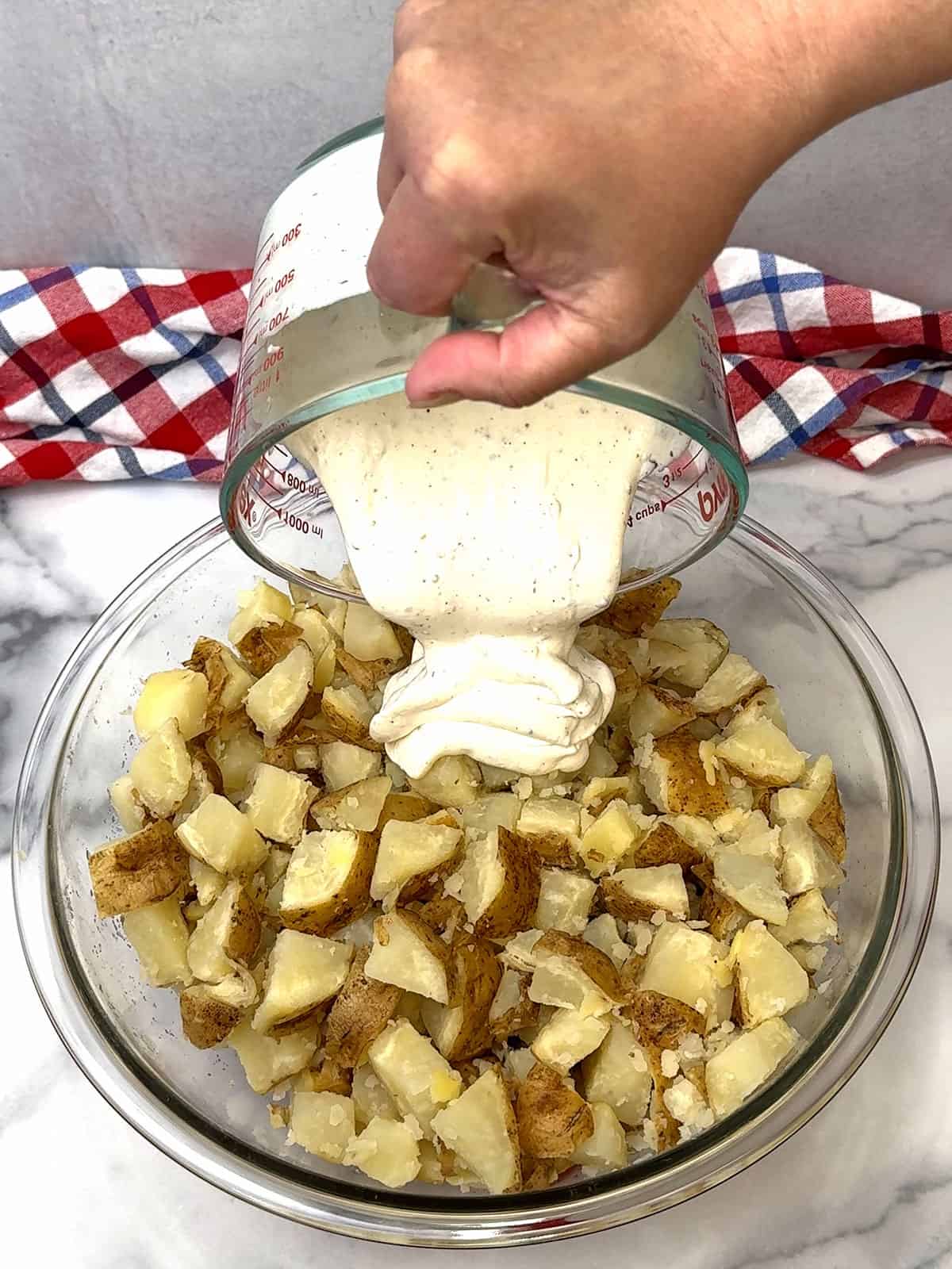 pouring dressing over potatoes