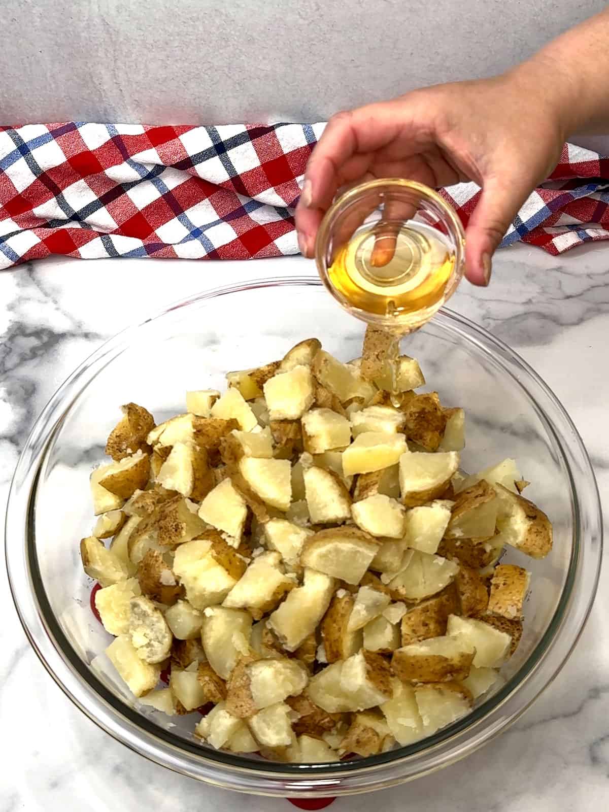 pouring vinegar over cut potatoes