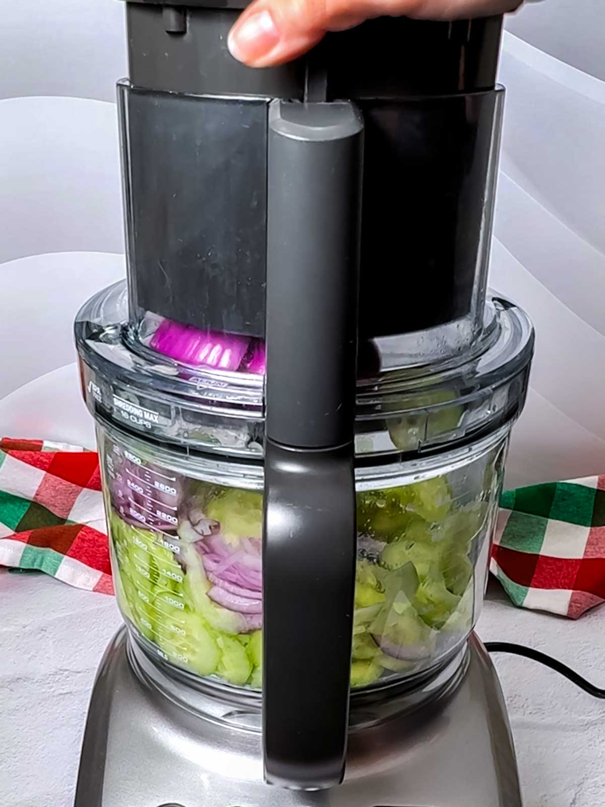 Slicing the cucumber and onion in a food processor.