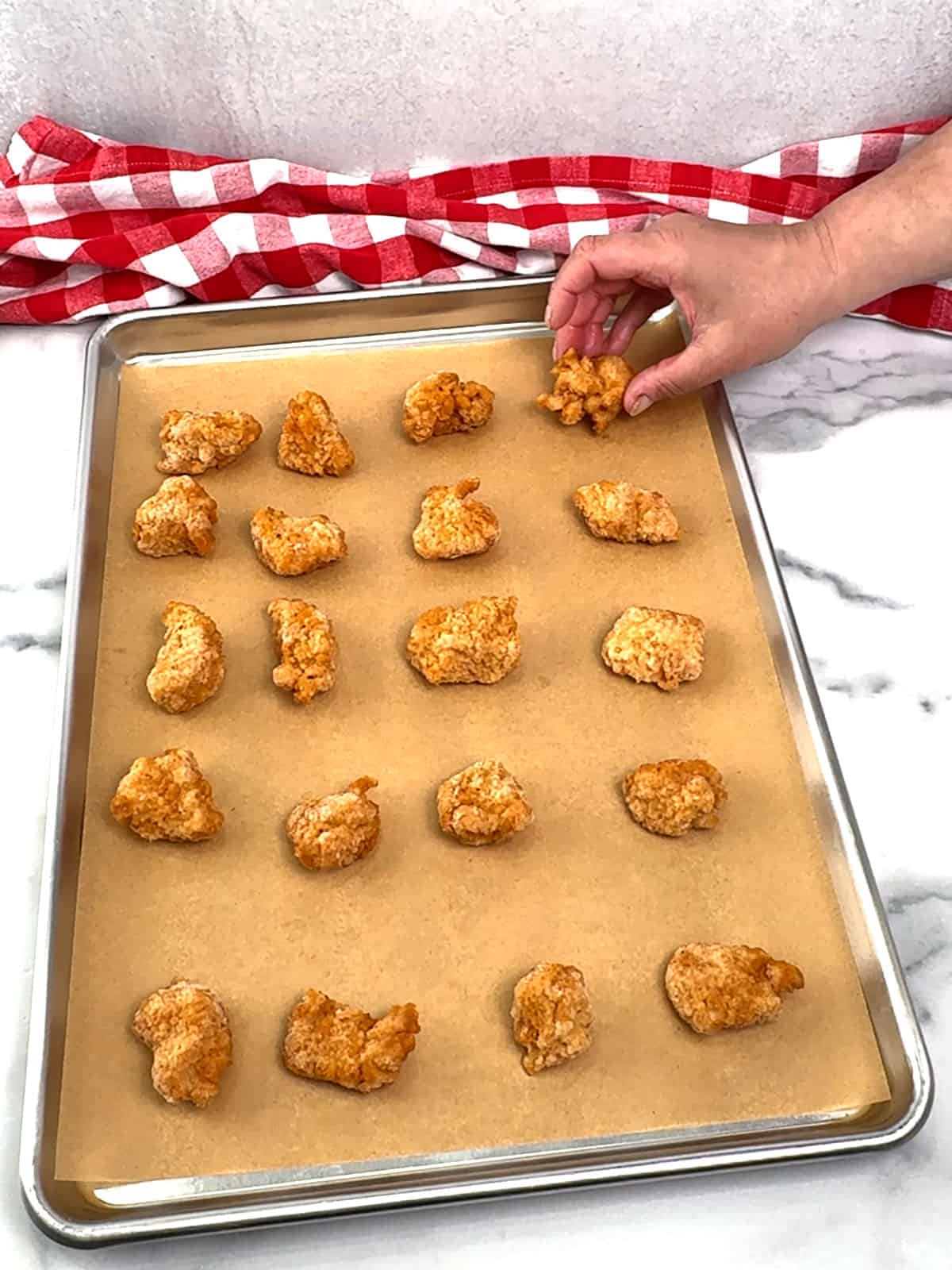 placing frozen chicken nuggets on sheet pan
