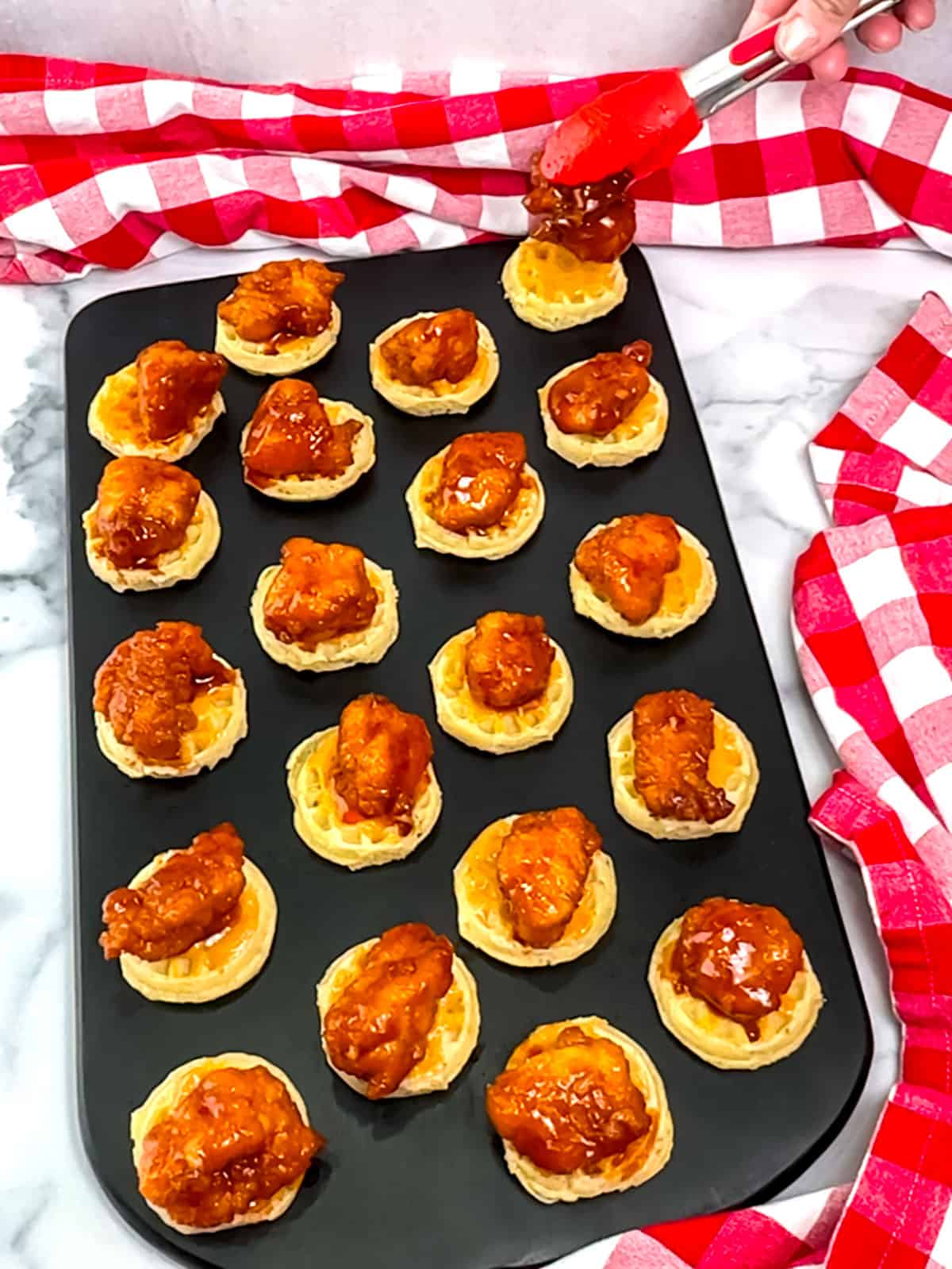 placing glazed nugget onto prepared waffles