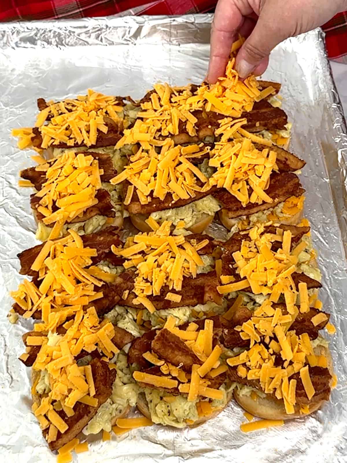 sprinkling cheese on top of bacon