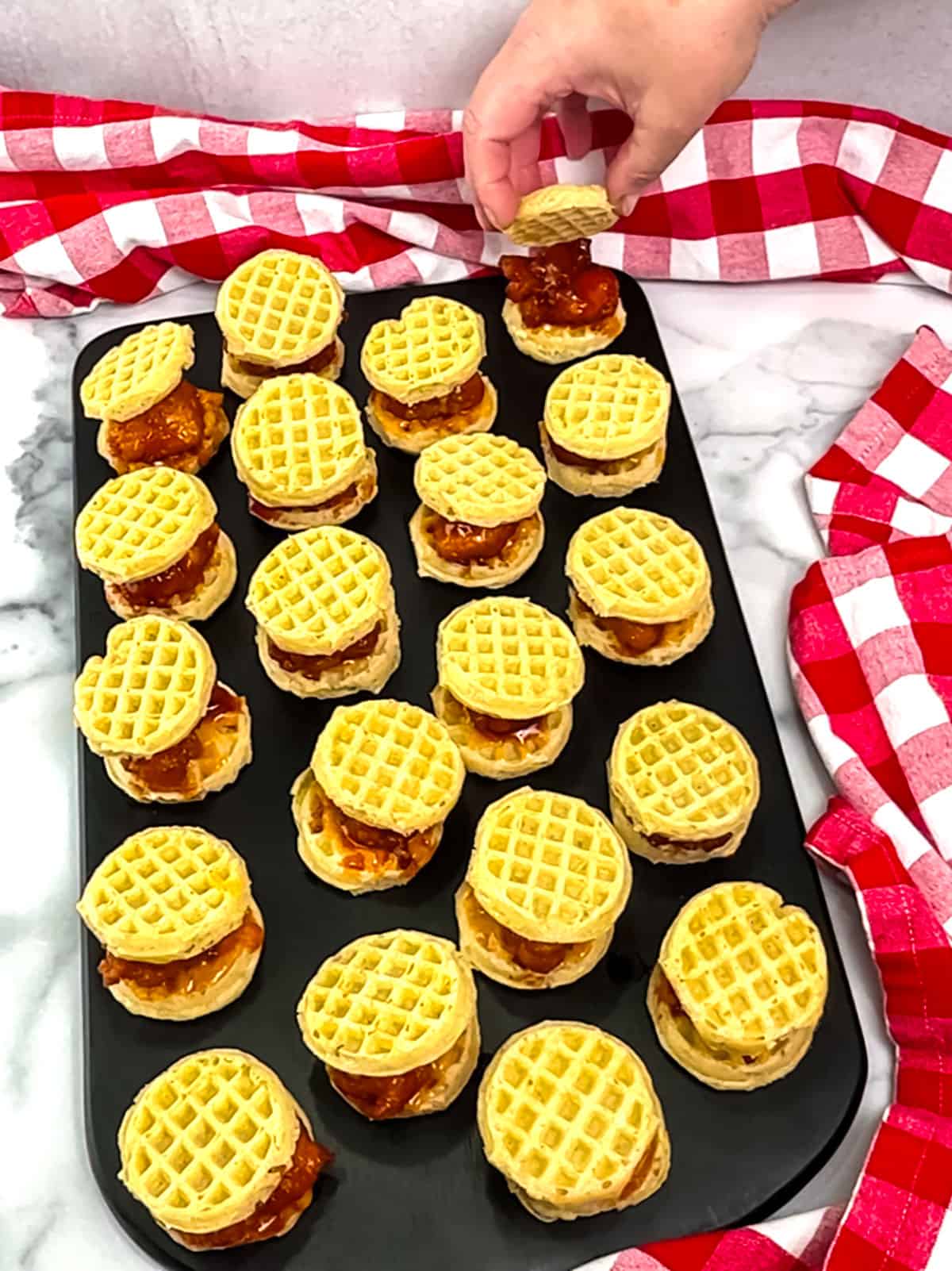 placing top waffles on nuggets