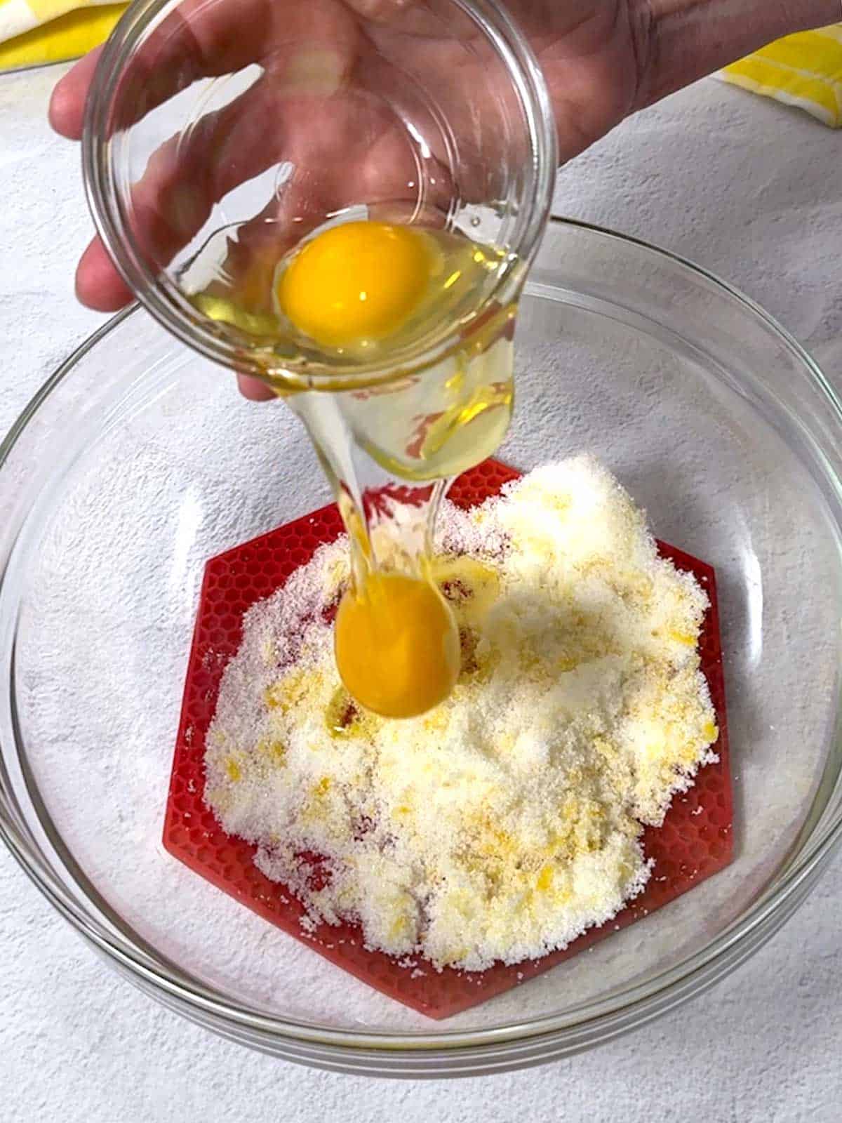 Adding eggs to the sugar and lemon mixture.
