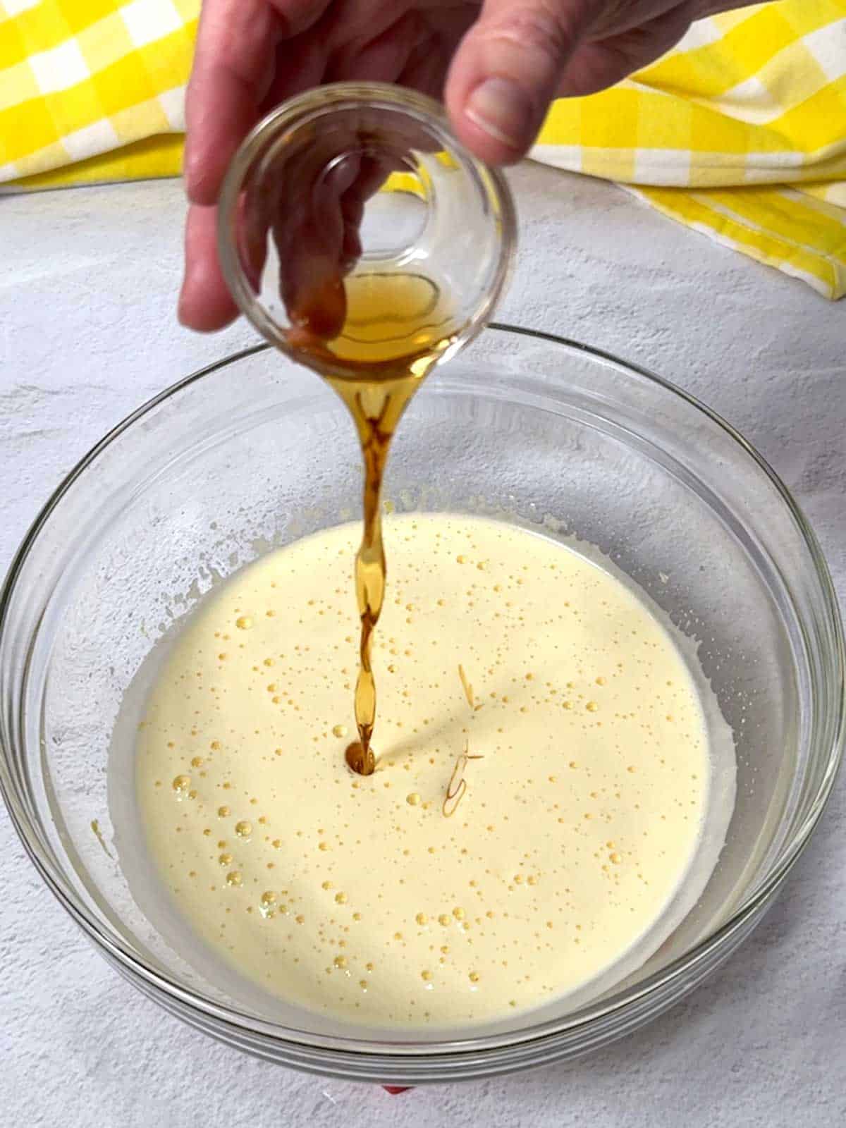 Adding vanilla extract to the madeleine batter.