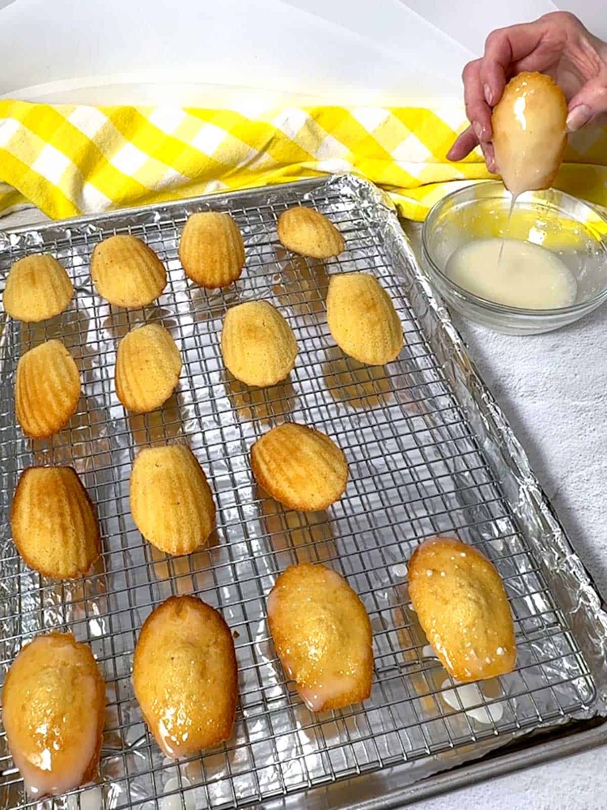 Dipping the madeleines into the lemon glaze.