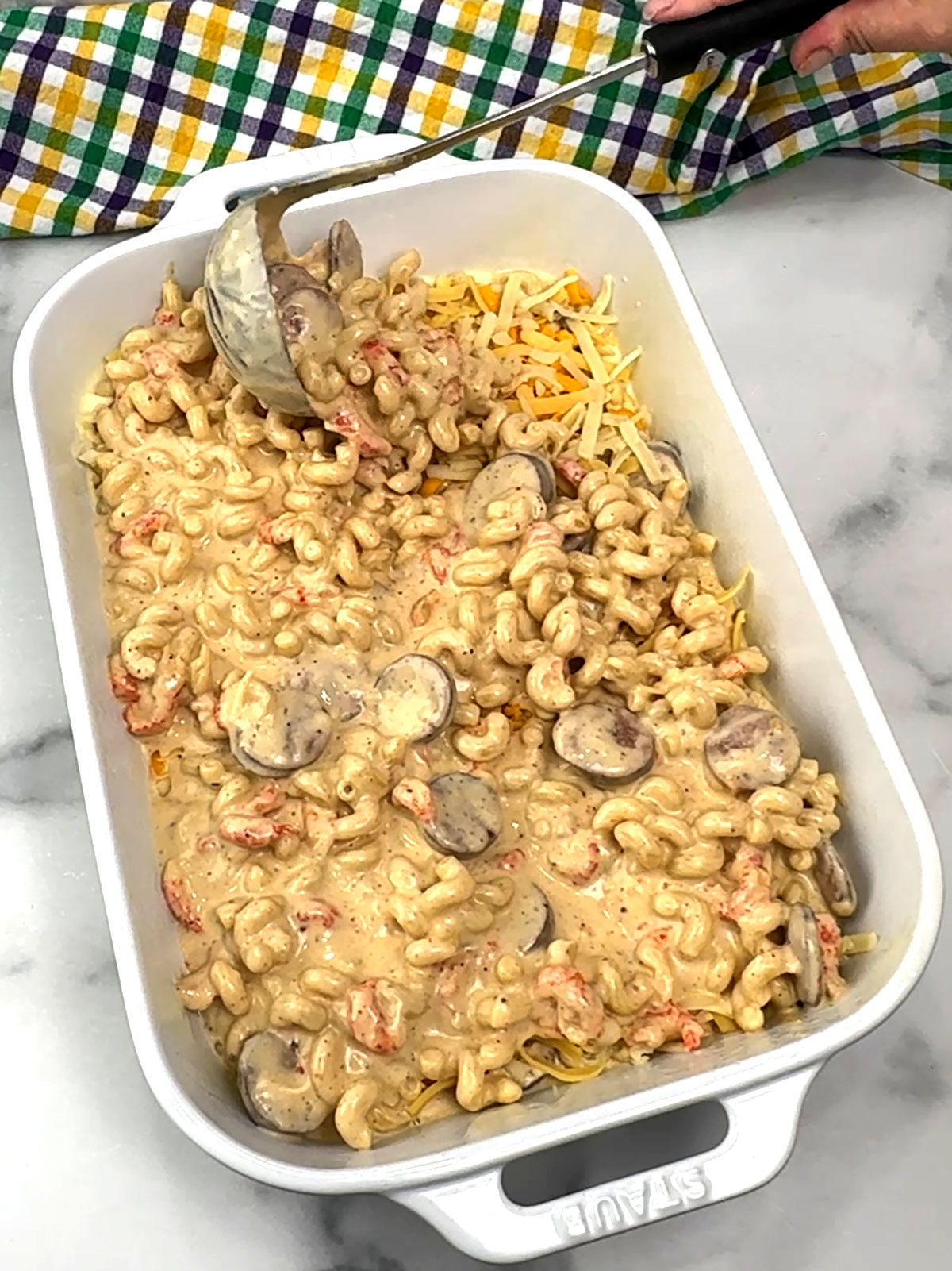 adding remaining pasta mixture to baking dish
