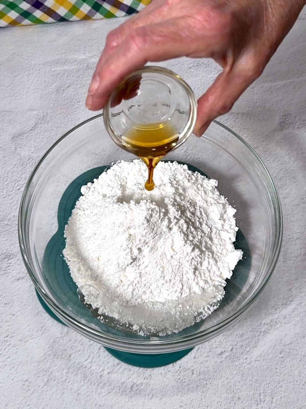 Adding vanilla extract to the other icing ingredients.
