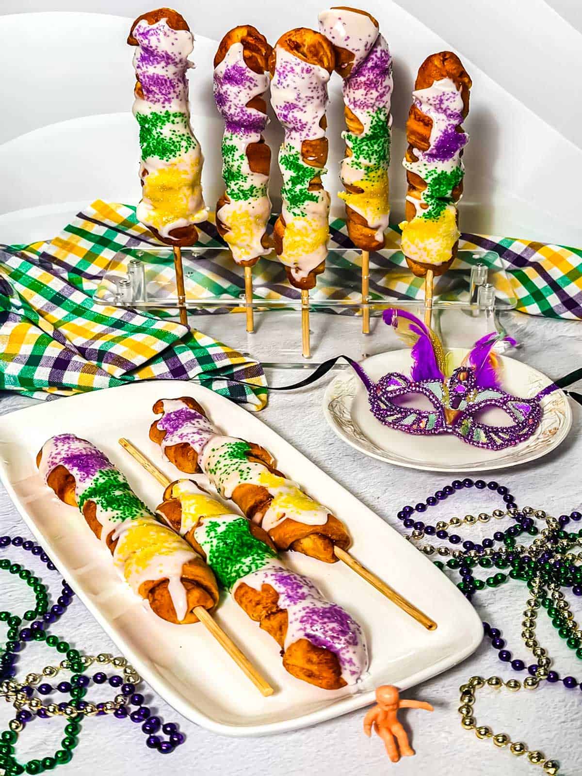 King cakes on a stick with Mardi Gras beads.