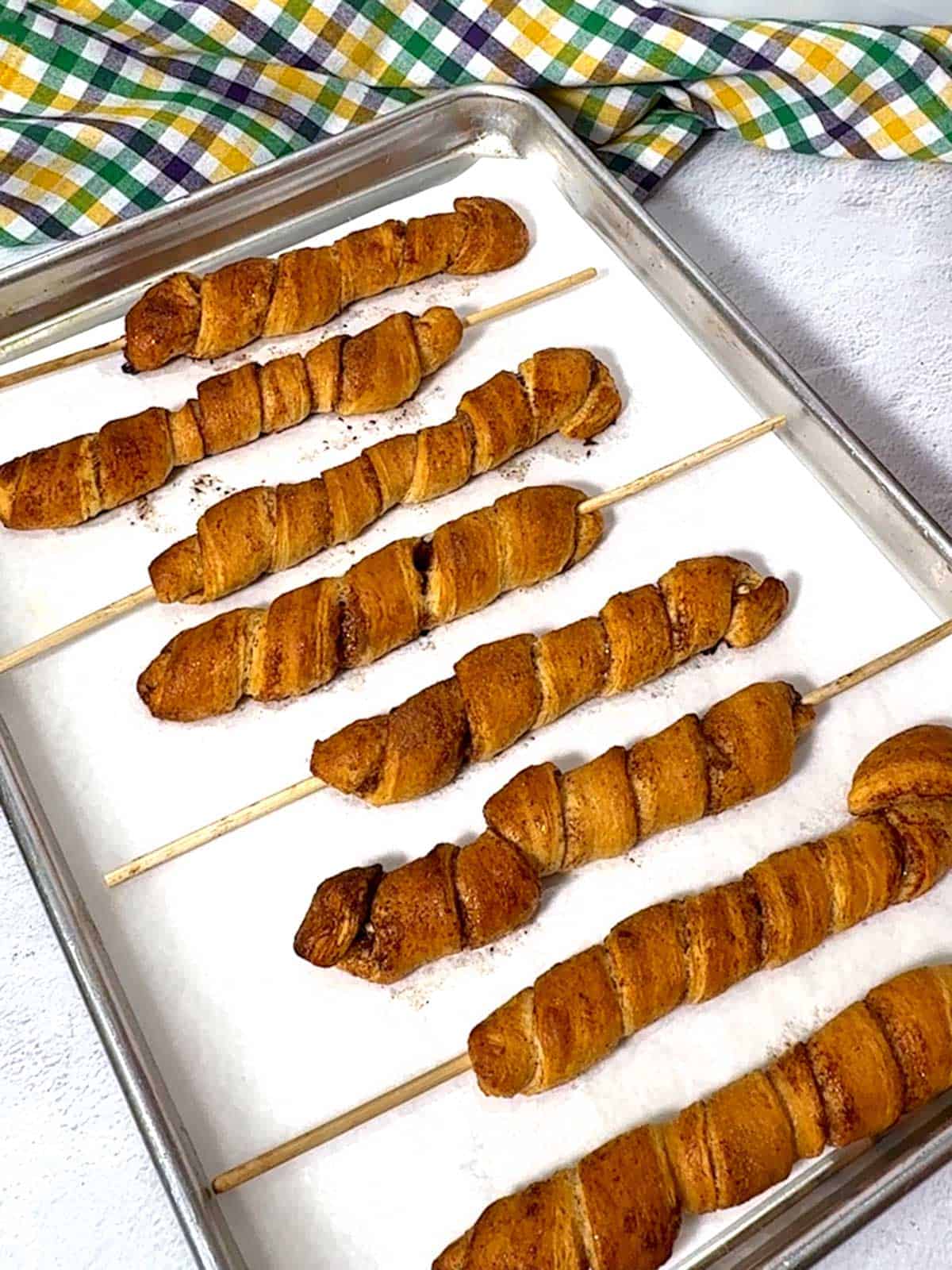 King cakes on a stick out of hte oven.
