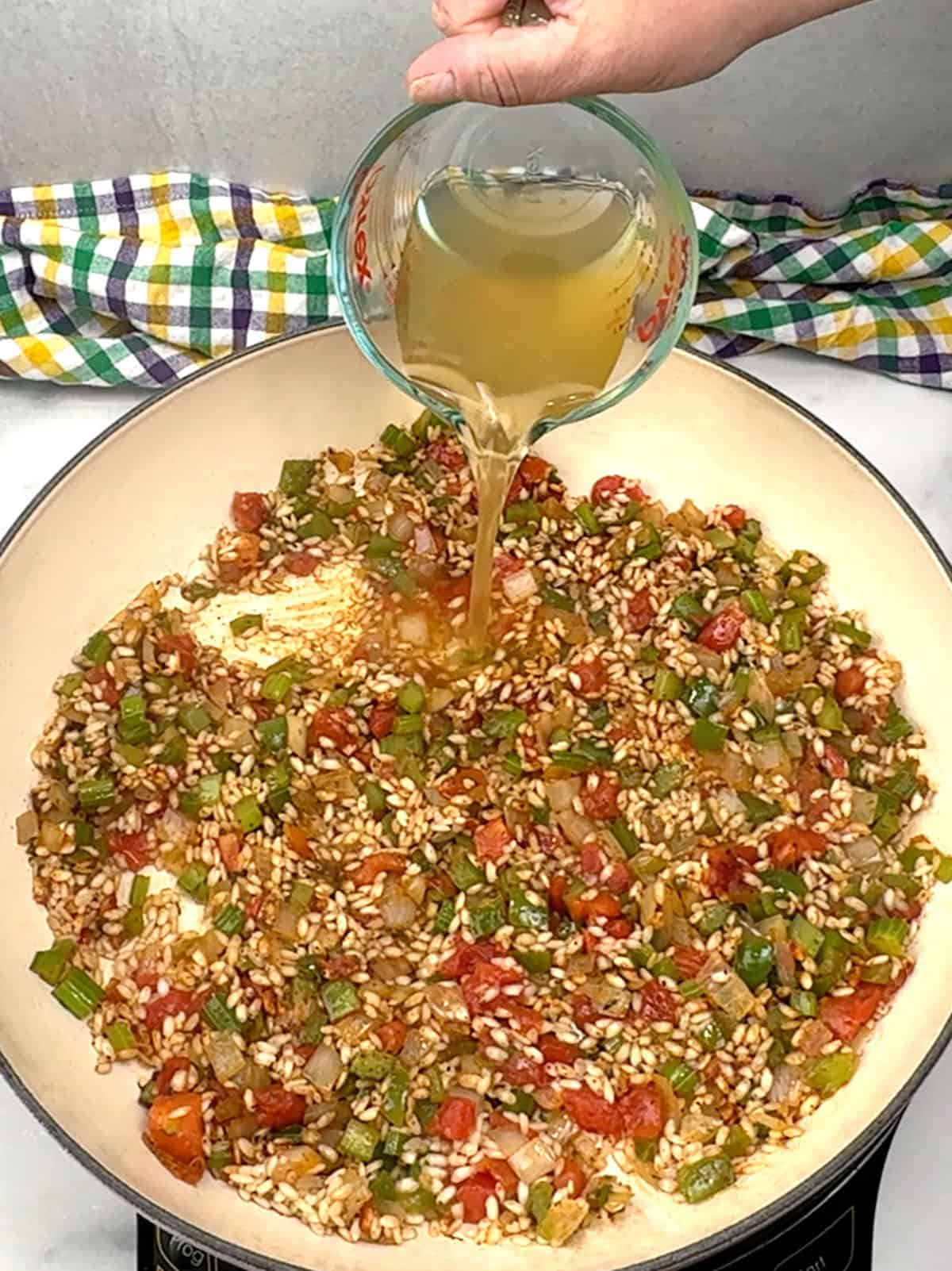 adding chicken broth to risotto