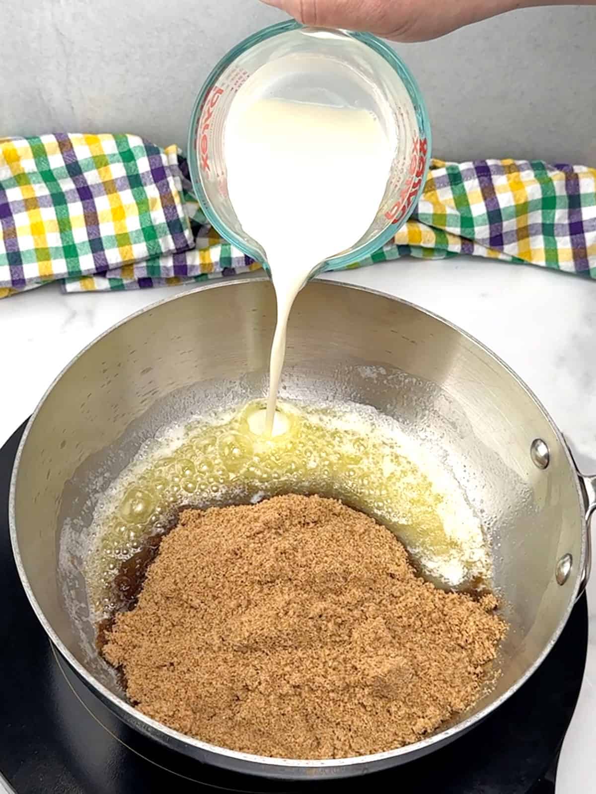 adding cream and brown sugar to melted butter for praline topping
