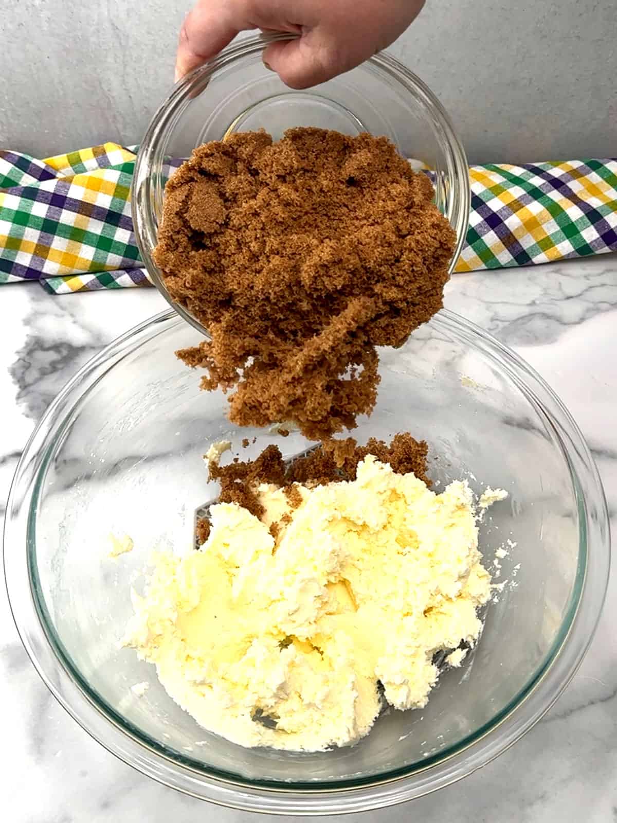 adding dark brown sugar to butter and cream cheese