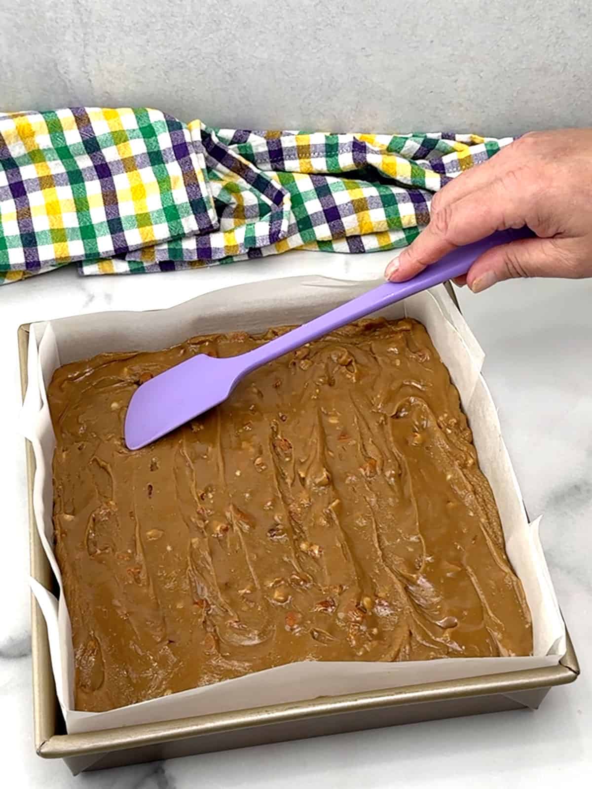 smoothing praline topping over brownies