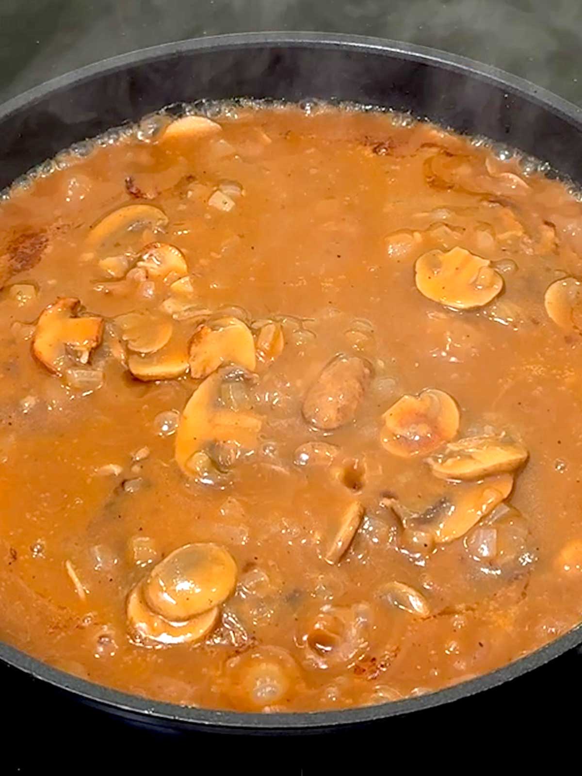 Gravy bubbling in the pan.