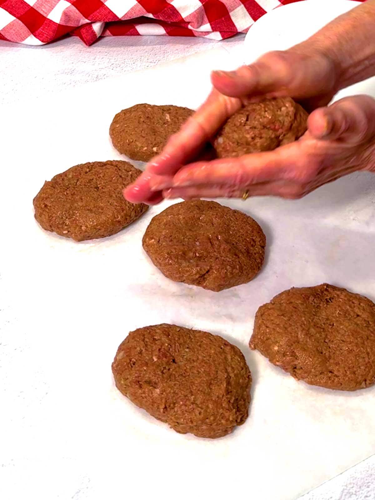 Forming the meat patties into an oval shape.