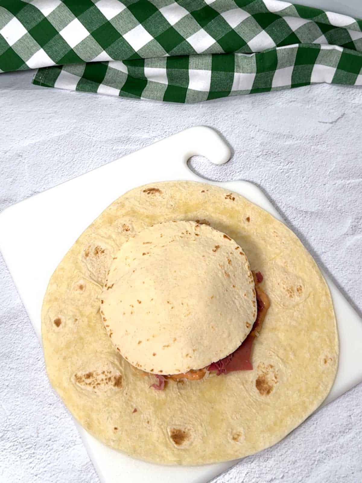 Smaller flour tortilla added on top of the layers.