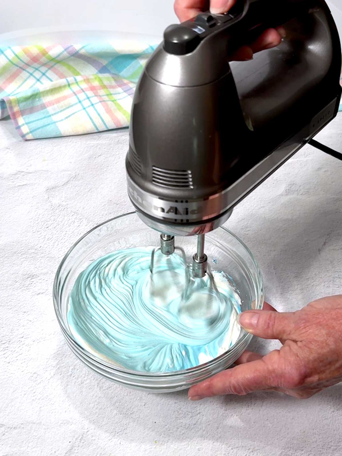 Beating the blue color into the mixture.