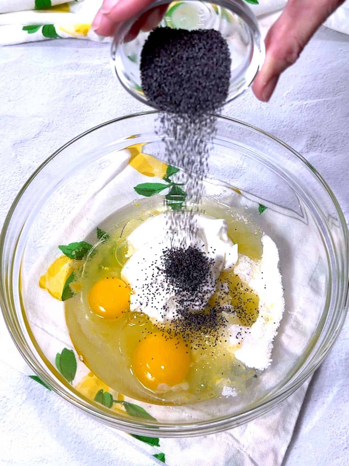 Adding poppy seeds to the other ingredients.