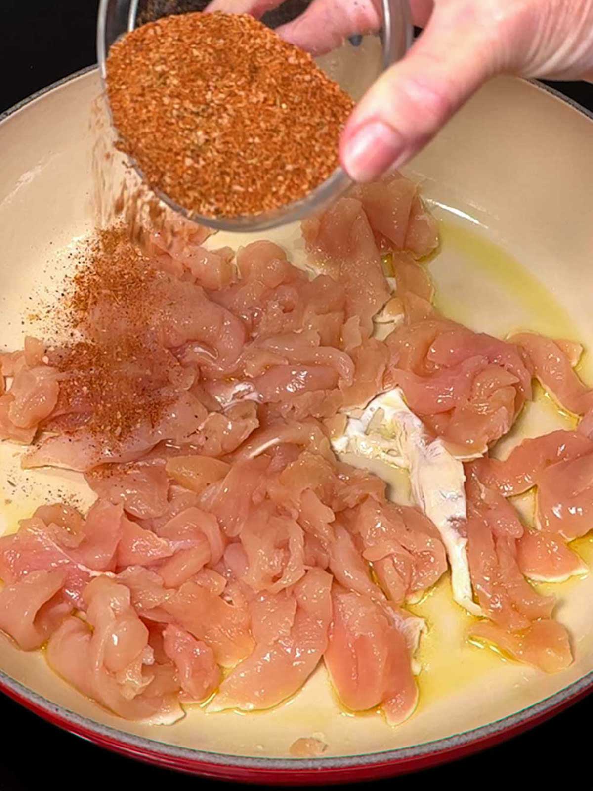 Adding spices to chicken.