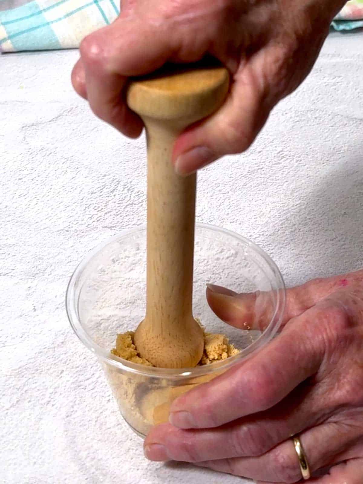 Flattening the crumbs with a tart tamper.