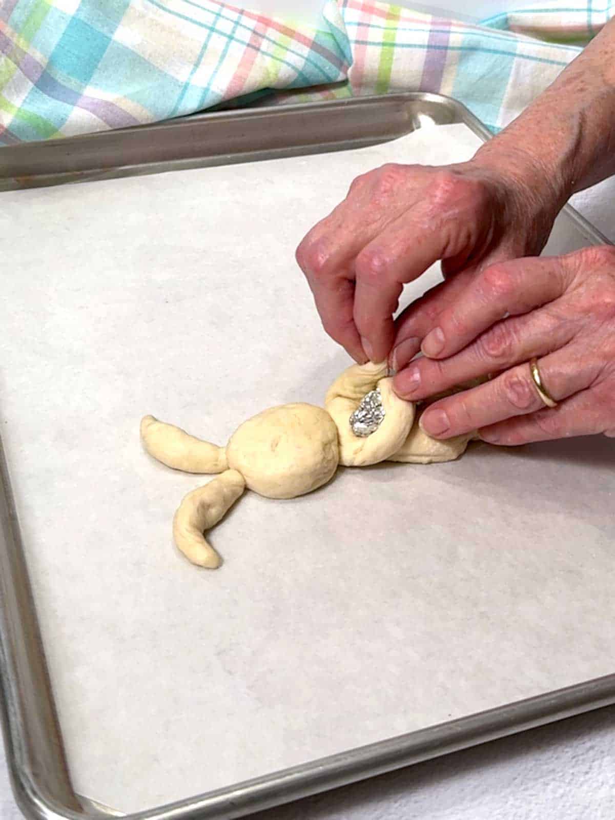 Wrapping the bunny's arms around a balled up piece of foil.