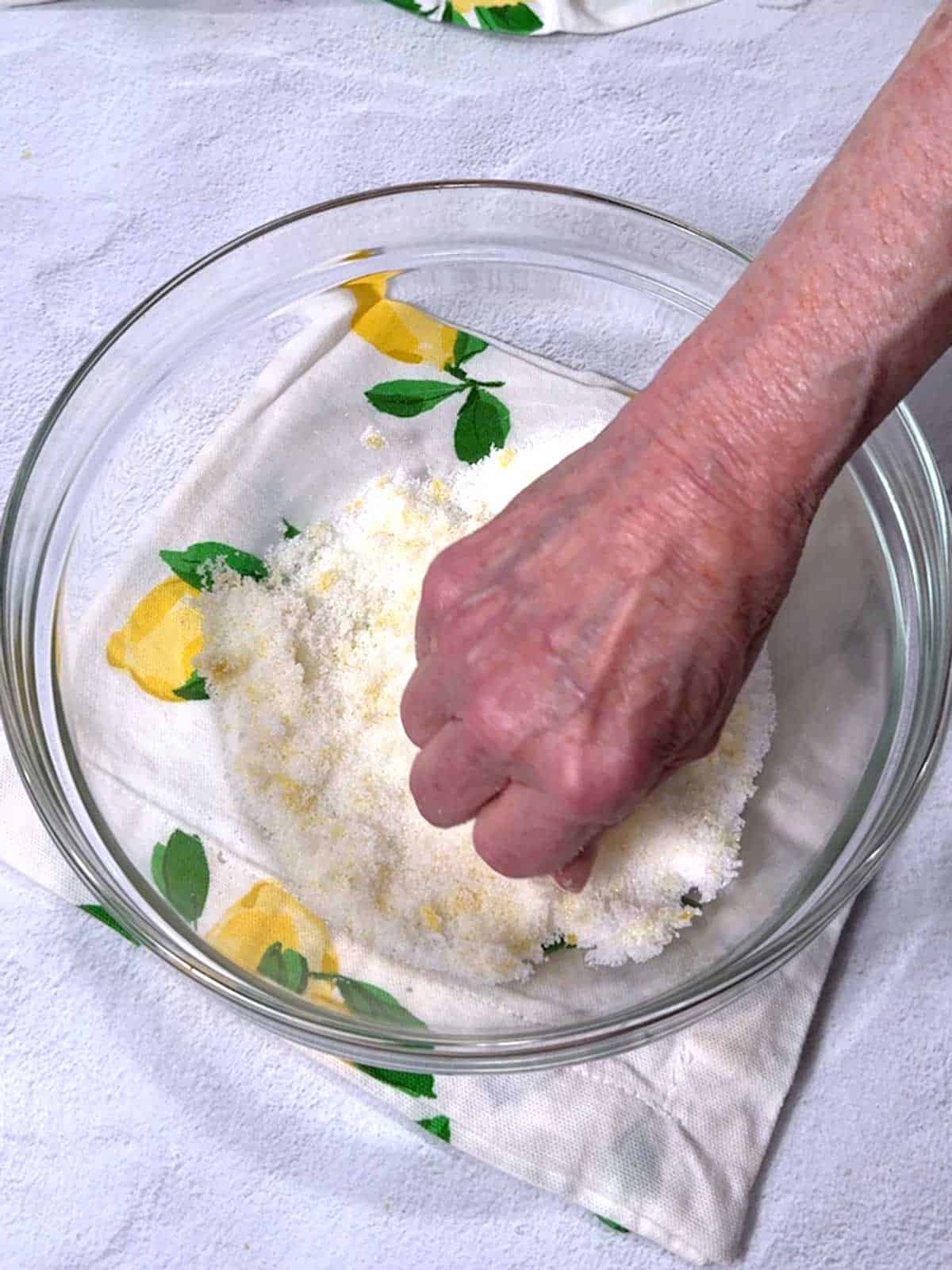 Rubbing lemon zest into sugar.