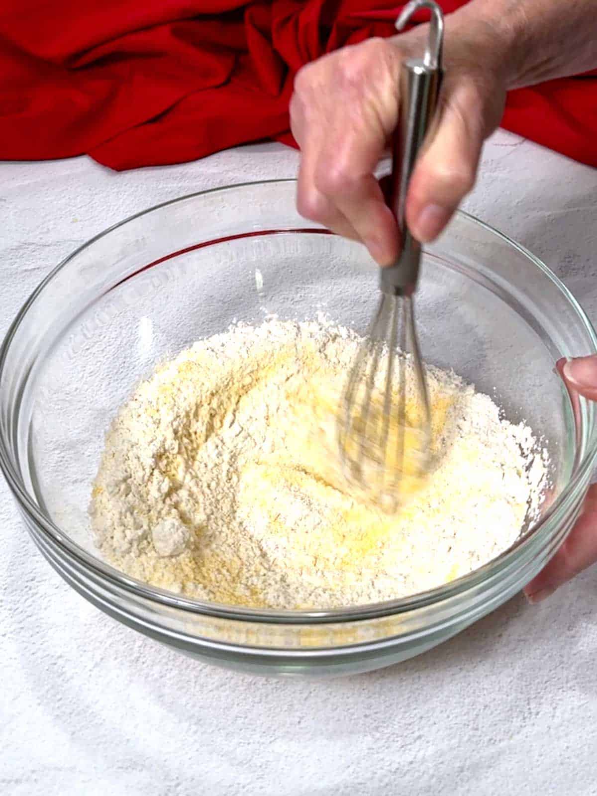 Whisking the cornmeal, flour, salt, baking soda, and cayenne pepper together in a large bowl.