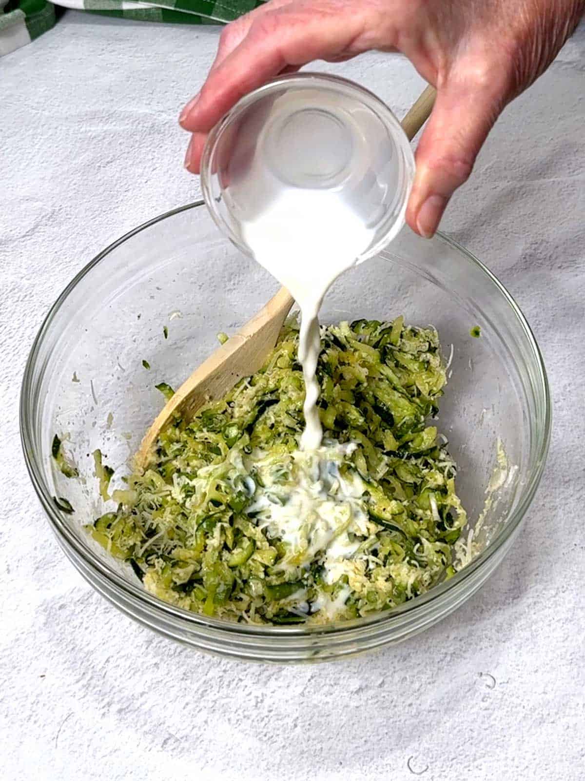 Adding milk to the zucchini mixtutre.