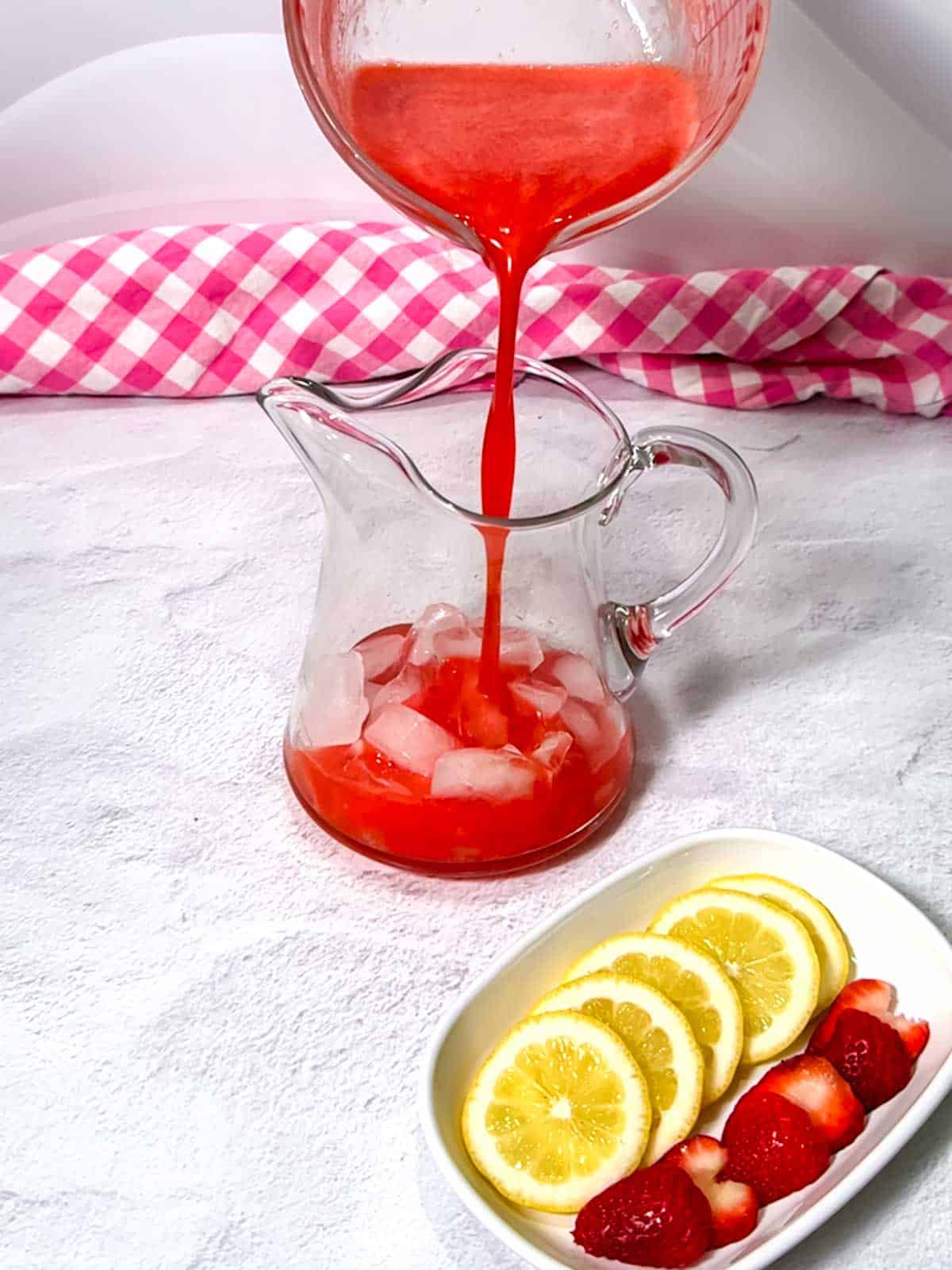 Adding strawberry mixture to the pitcher.
