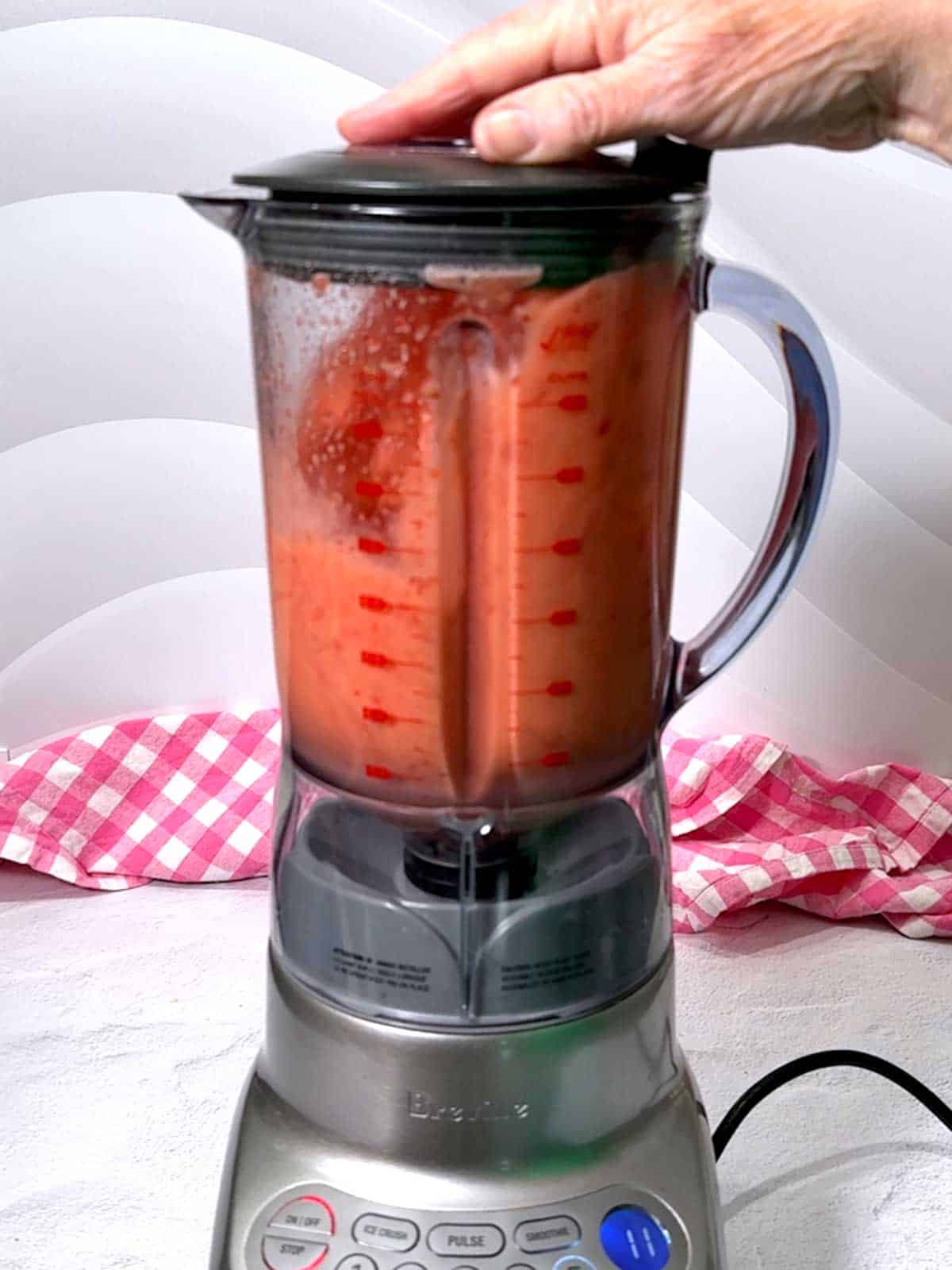 Blending ingredients for the strawberry sparkling lemonade in the blender.