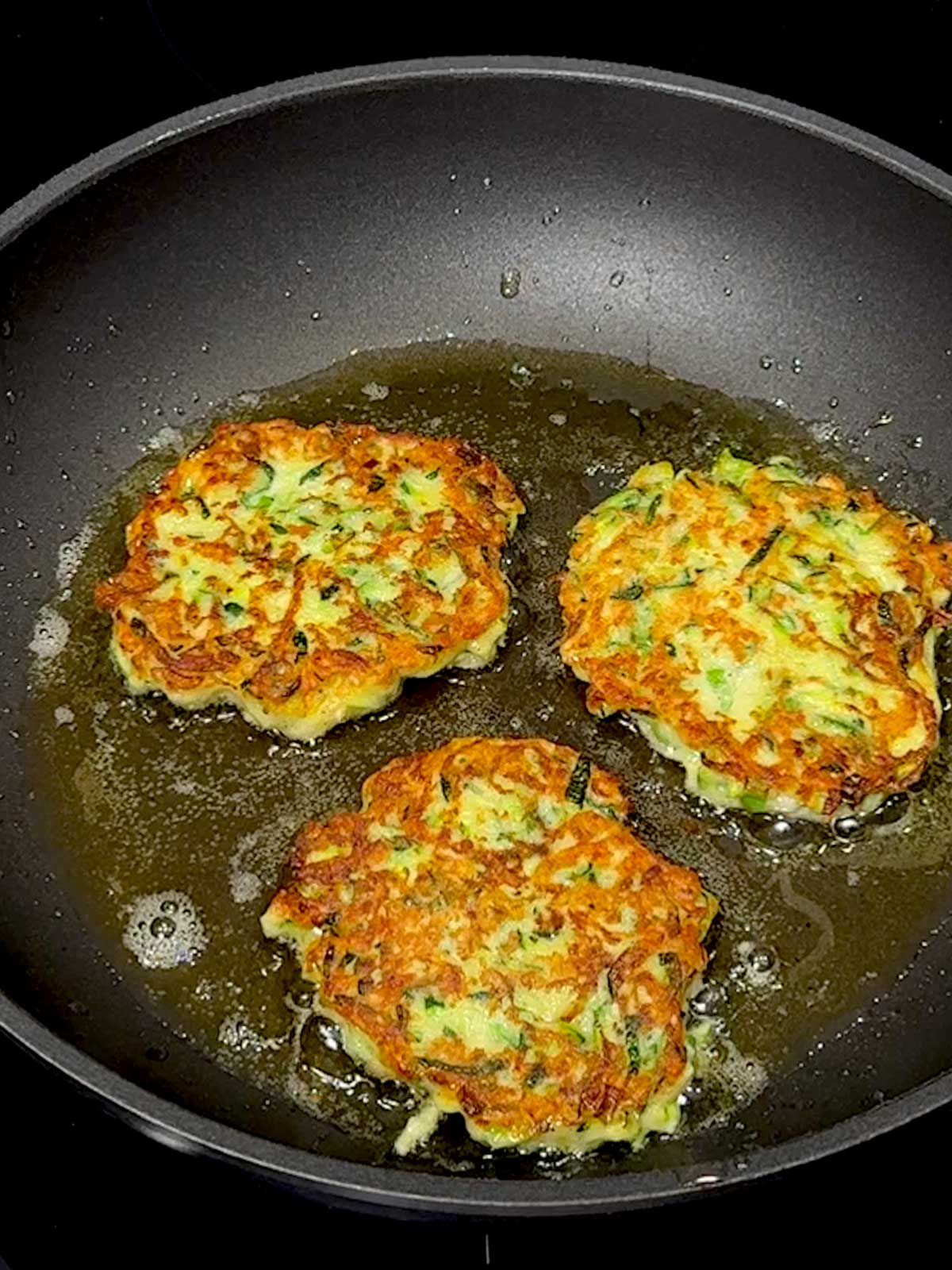 Cooking the second side of the fritters.
