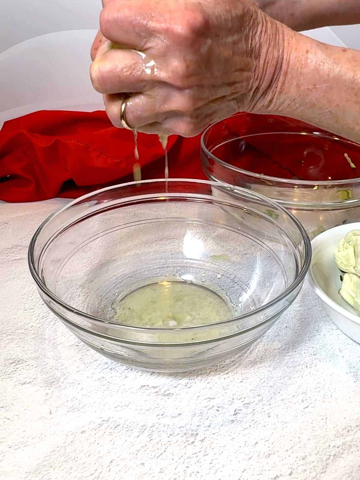 Squeezing zucchini in paper towels.