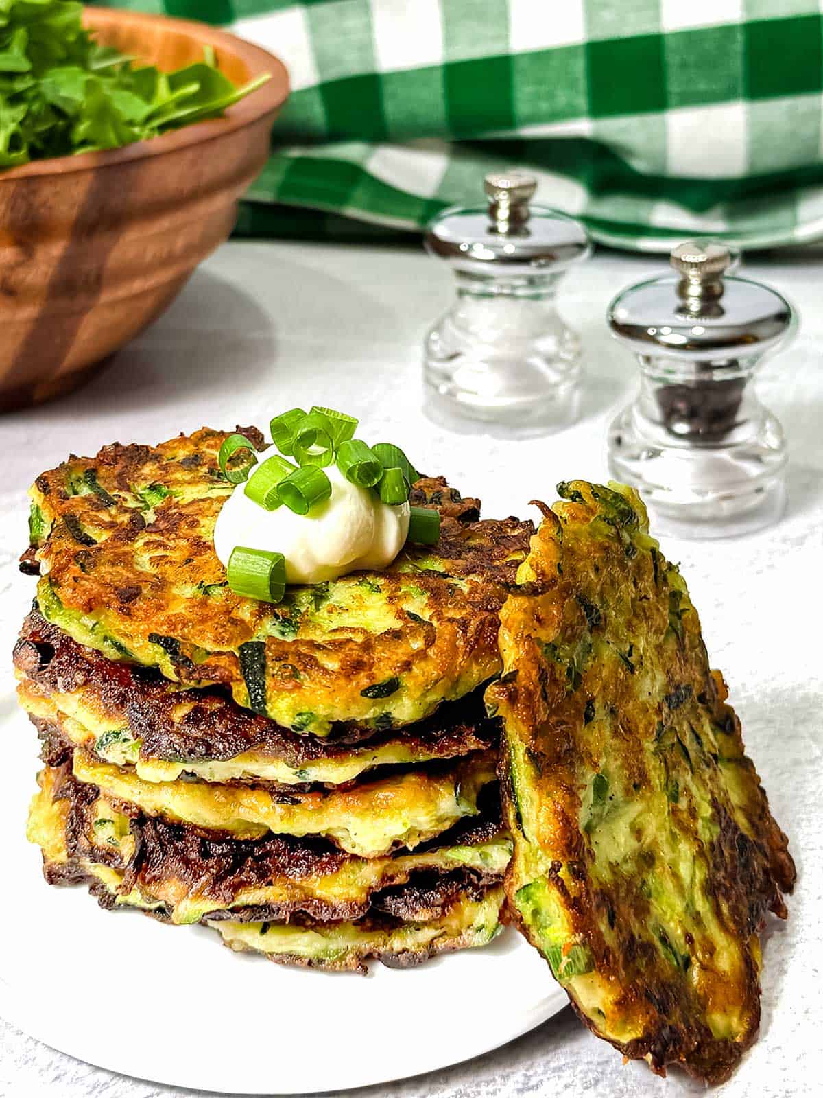Zucchini fritters with a dollup of sour cream on top.
