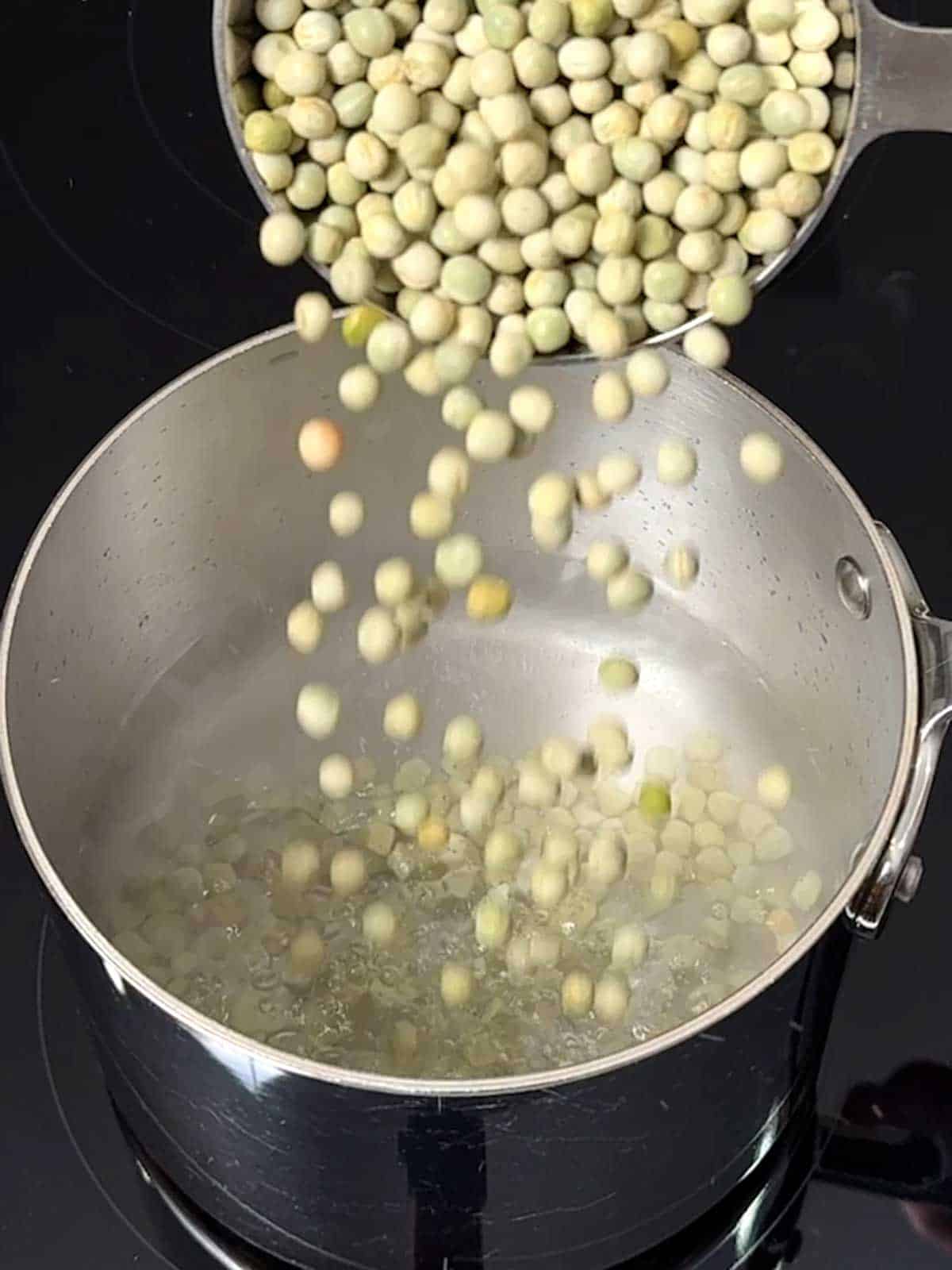 Adding dried peas to a pan of water.
