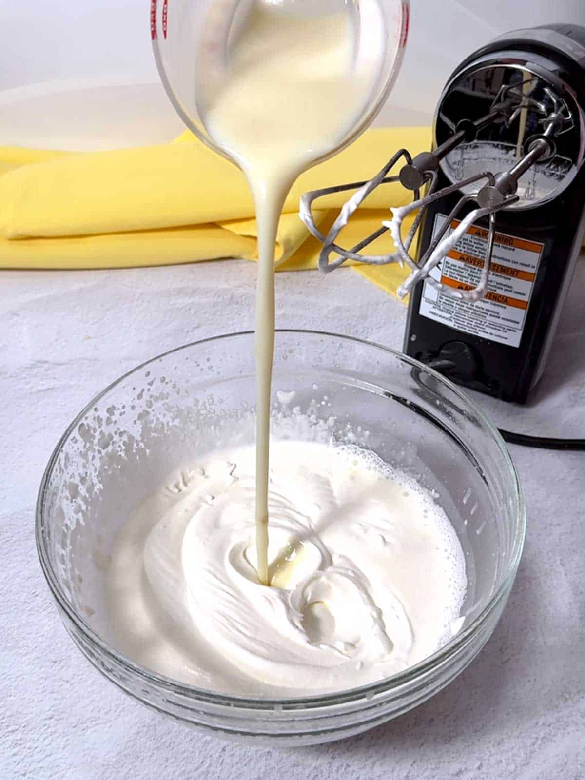 Adding the milk/sugar mixgture to the whipped cream.