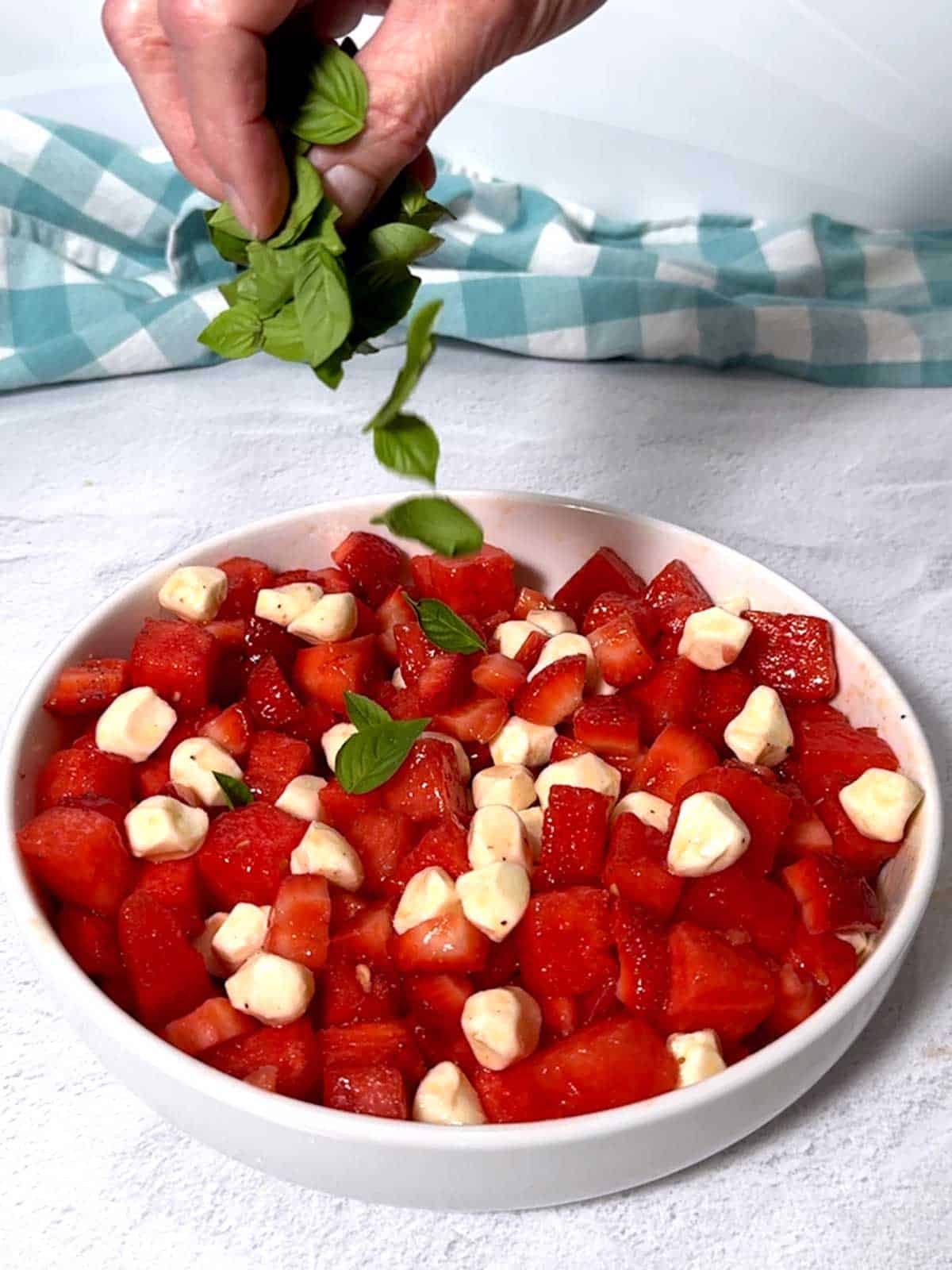 Sprinkling fresh basil on the watermelon, 