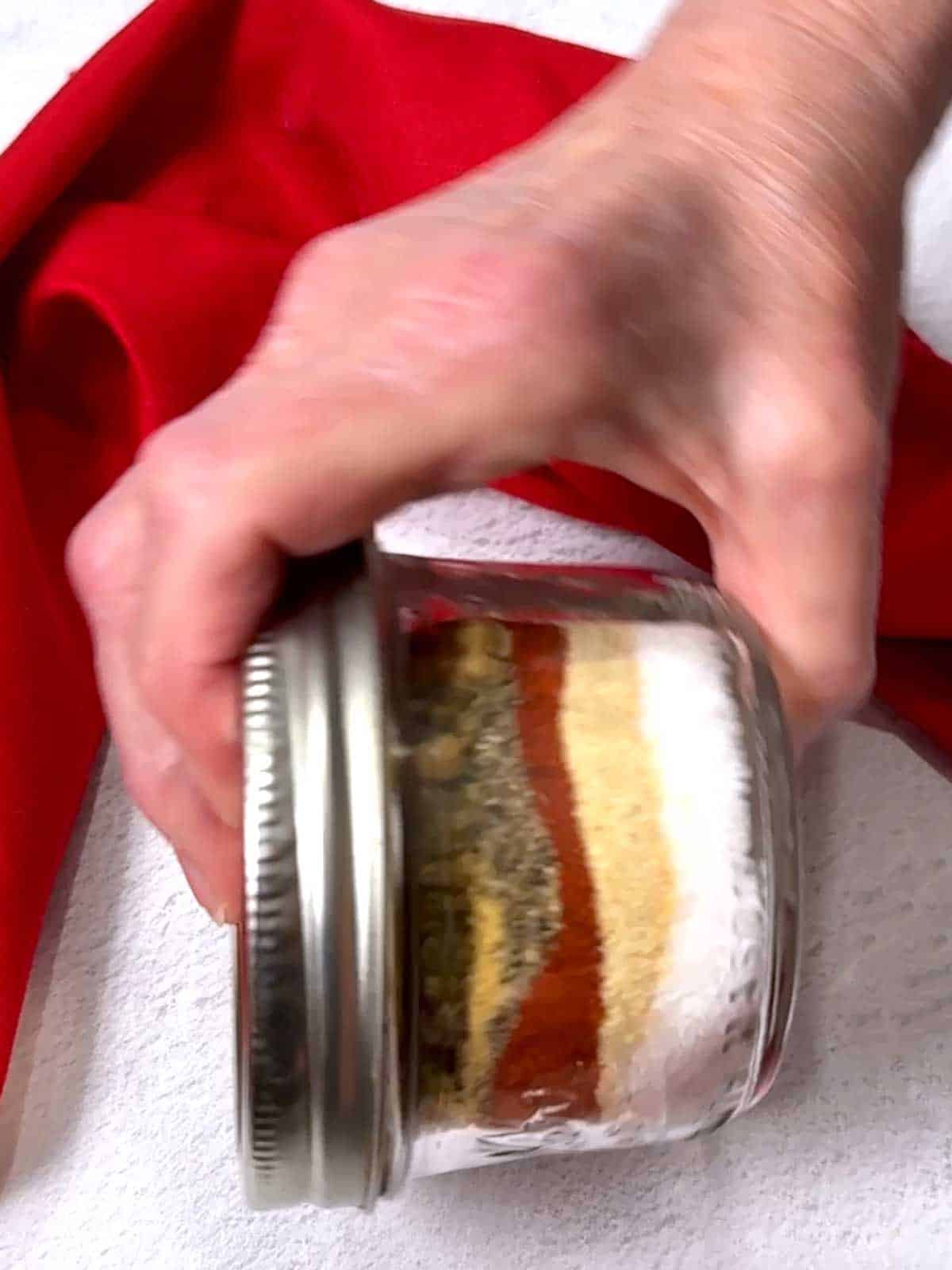 Shaking the ingredients in a jar with a lid.