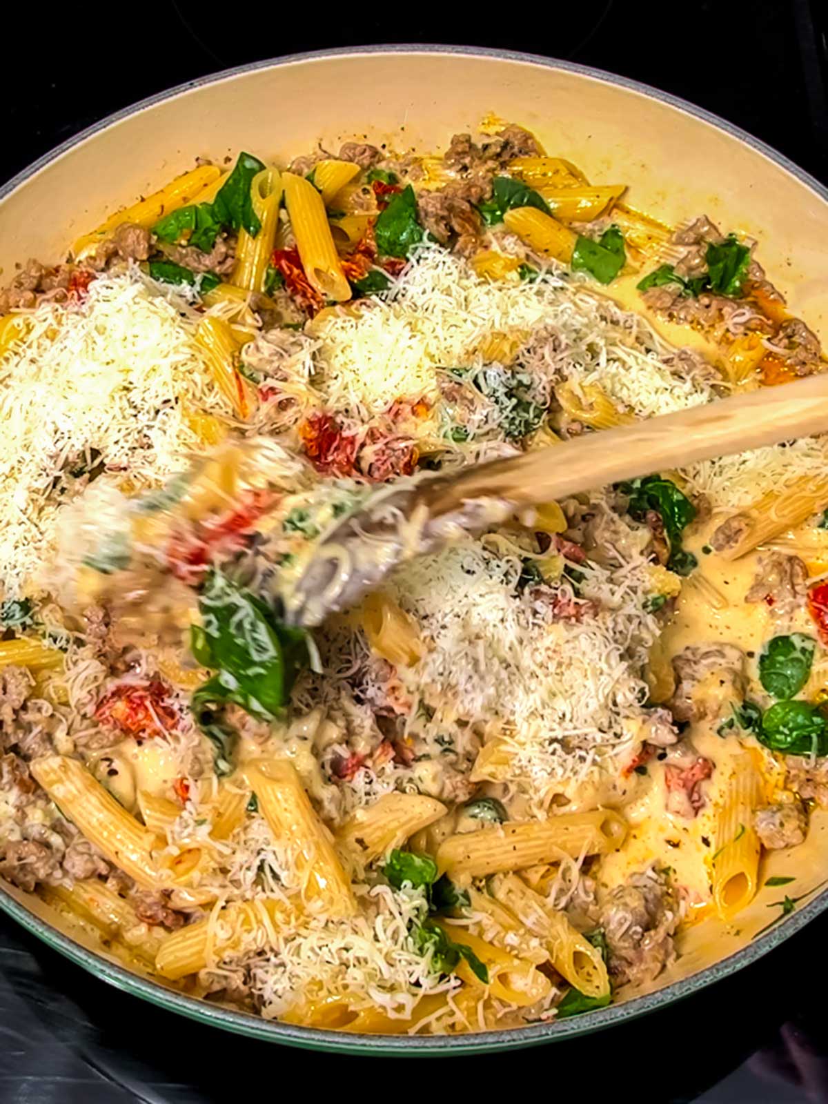 Stirring parmesan cheese into braiser.